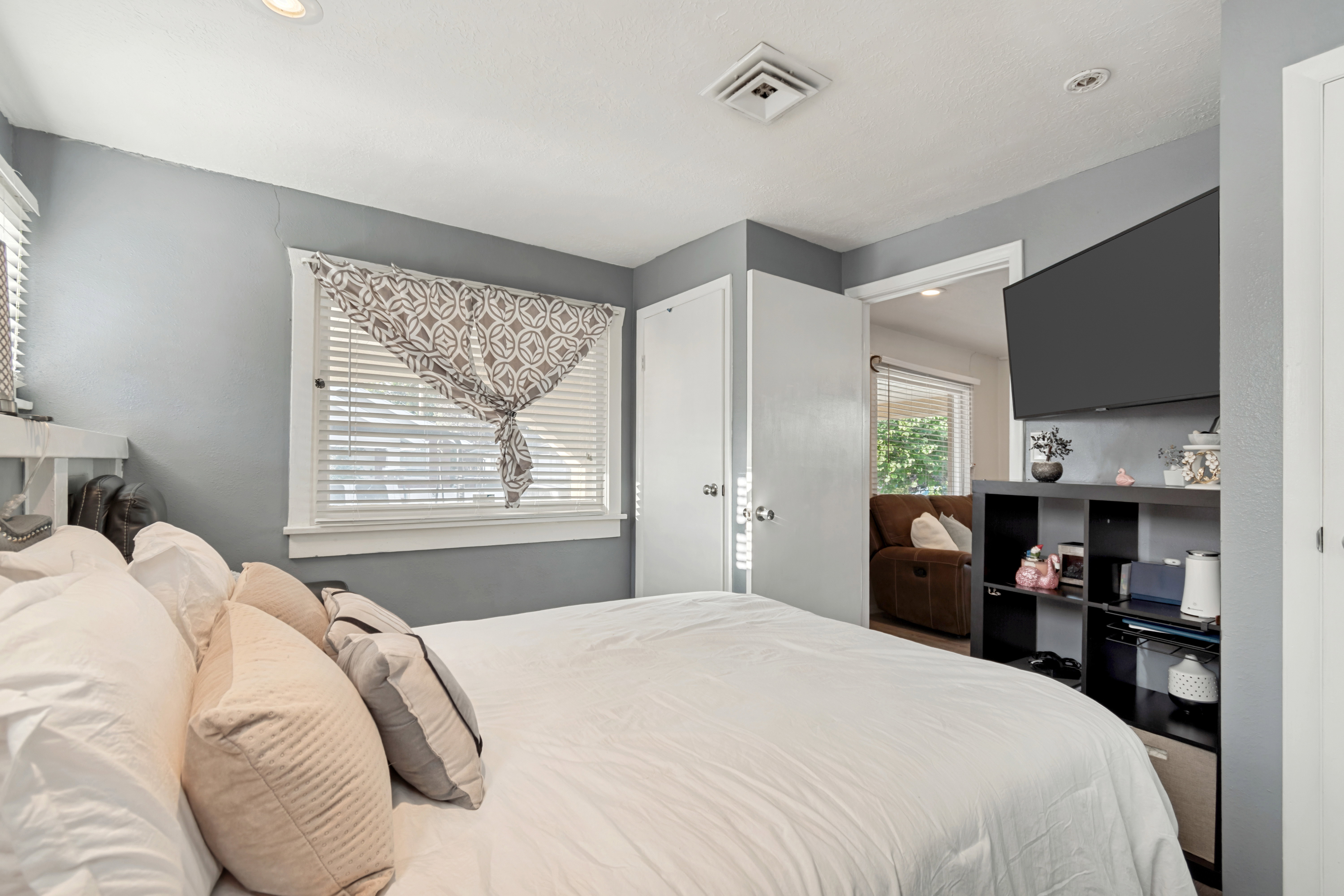 Bedroom featuring a window with white blinds, recessed lighting, gray painted walls, and a white ceiling
