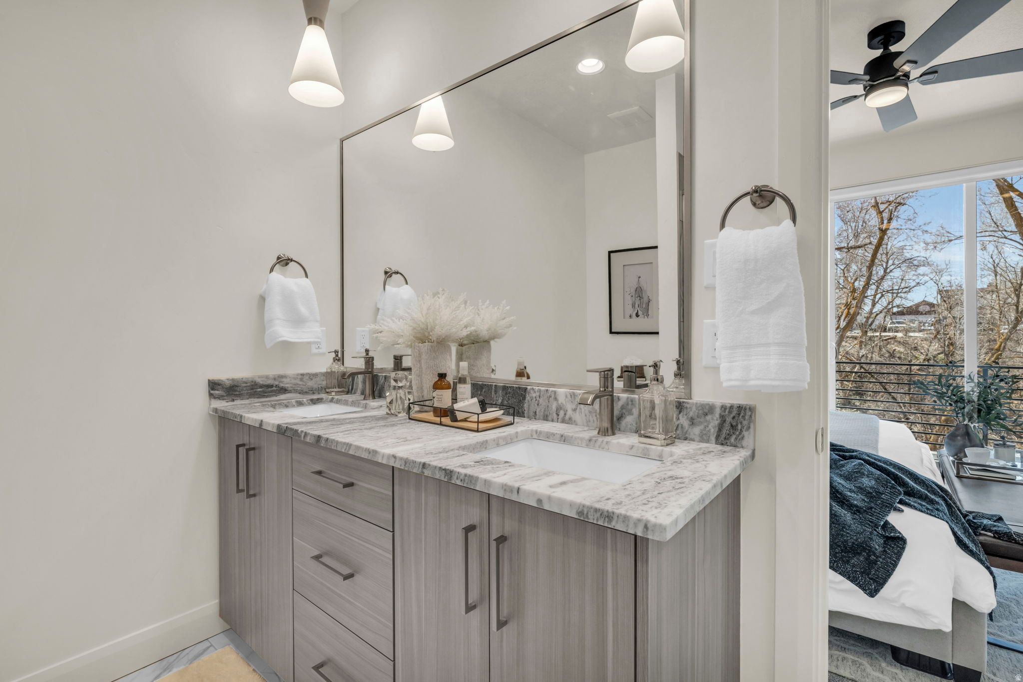 Double vanity with gray wood-finish cabinetry, integrated sinks, and polished chrome faucets