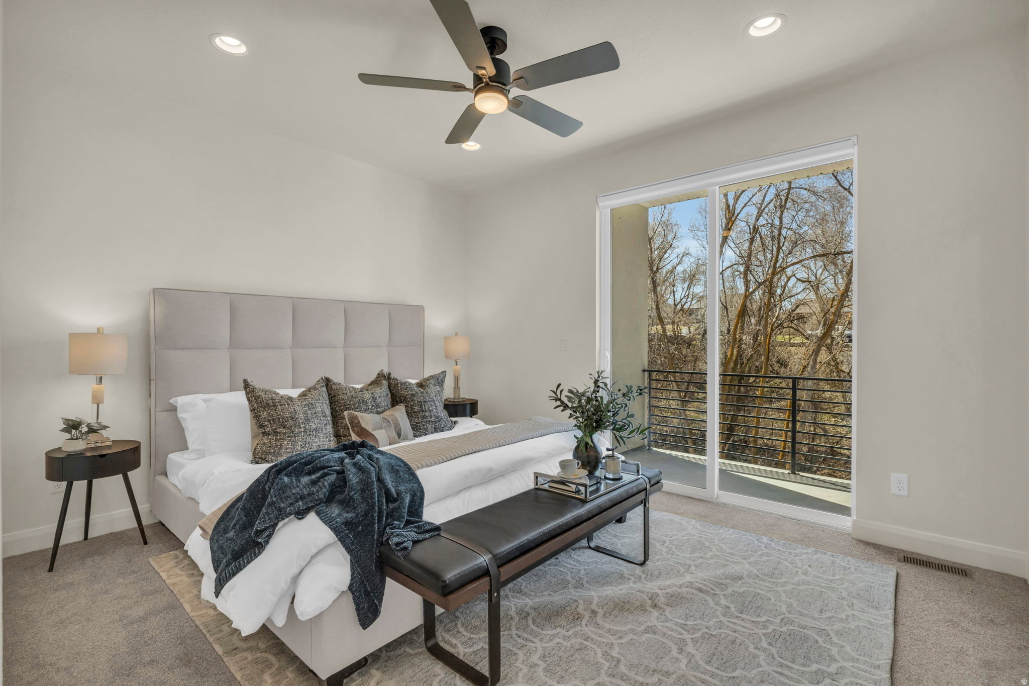Sliding glass doors open to a private balcony with black metal railings