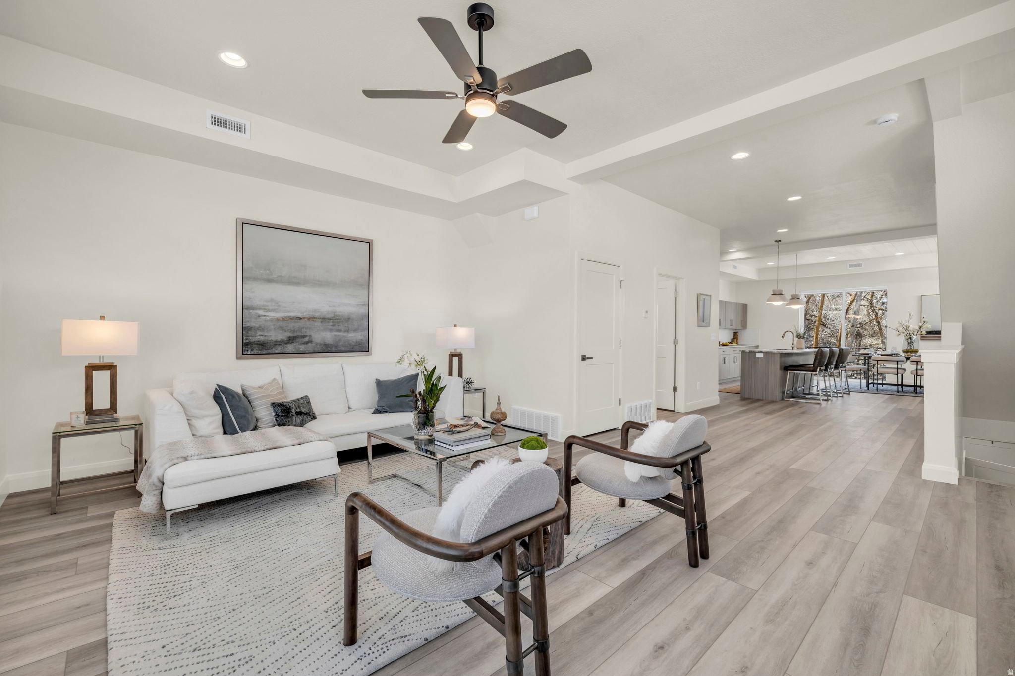 Spacious living area featuring wood-finish flooring, recessed lighting, and a modern ceiling fan