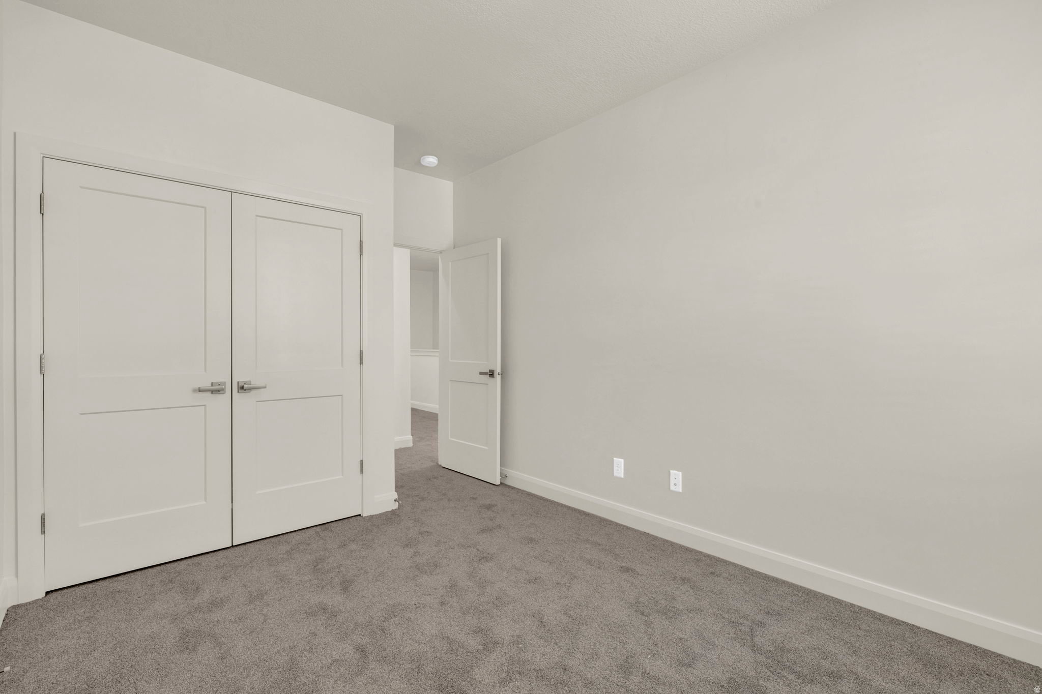 Neutral wall tones and gray carpeting