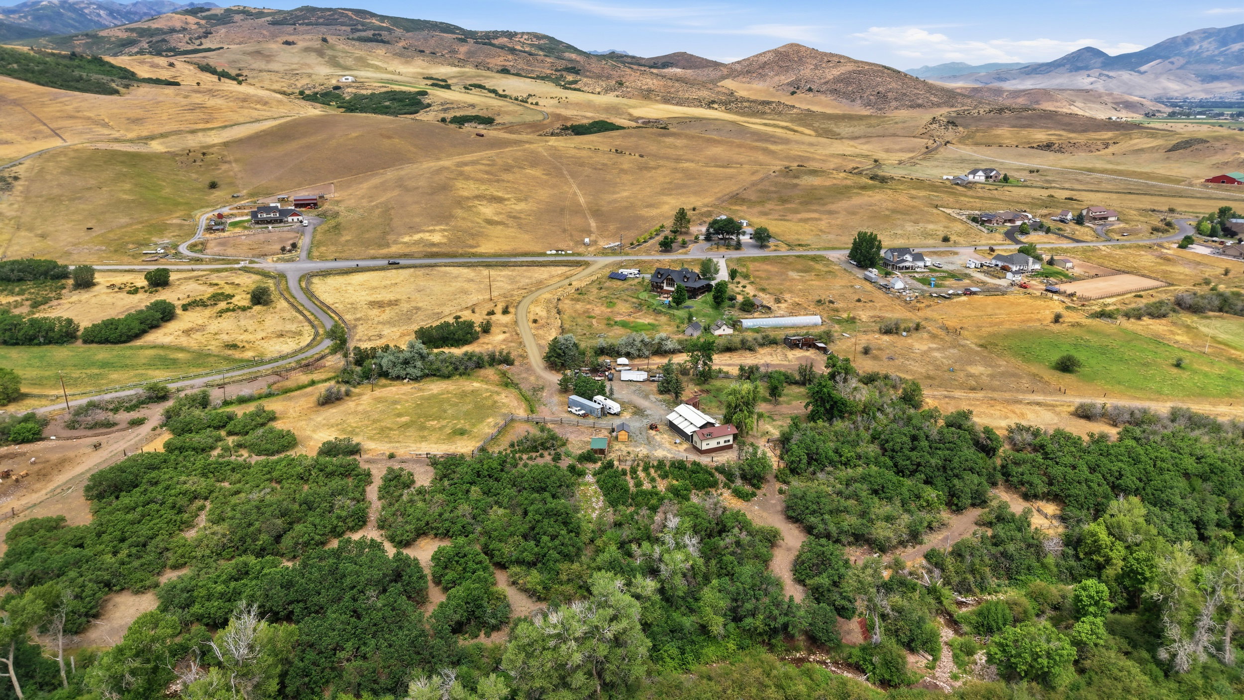 Expansive rural property featuring multiple structures, open land, and surrounding mountain terrain