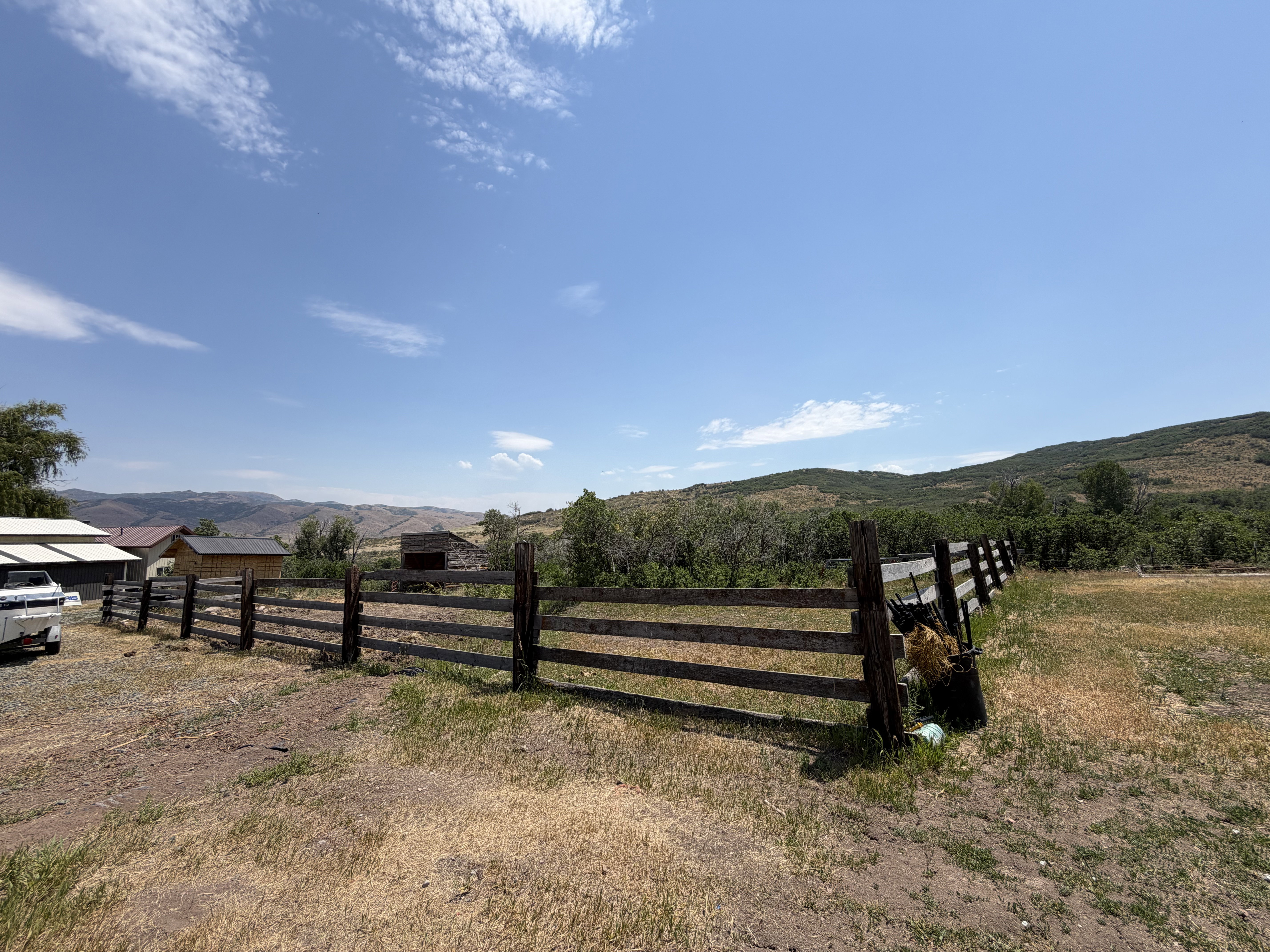 Spacious outdoor area featuring a wooden fence line and natural landscaping