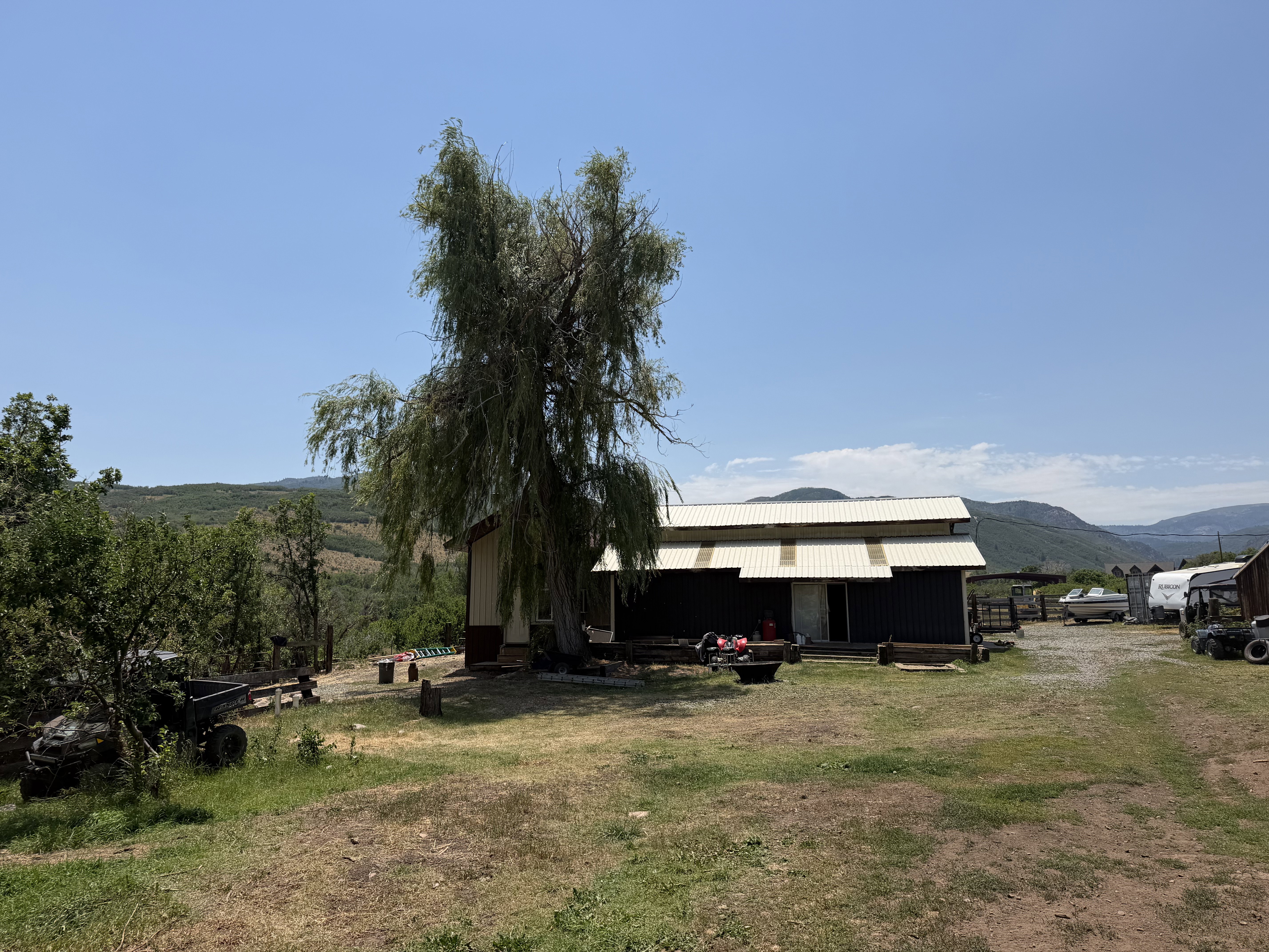 Metal-sided outbuilding with a white corrugated metal roof