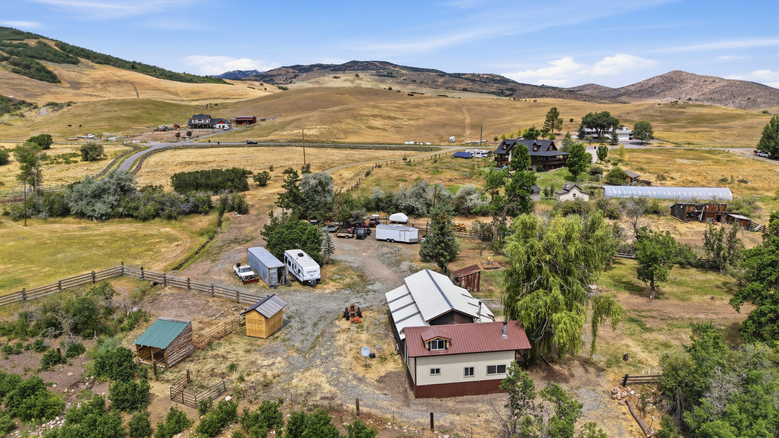 Expansive property featuring a mix of natural landscaping and cleared areas, surrounded by rolling hills