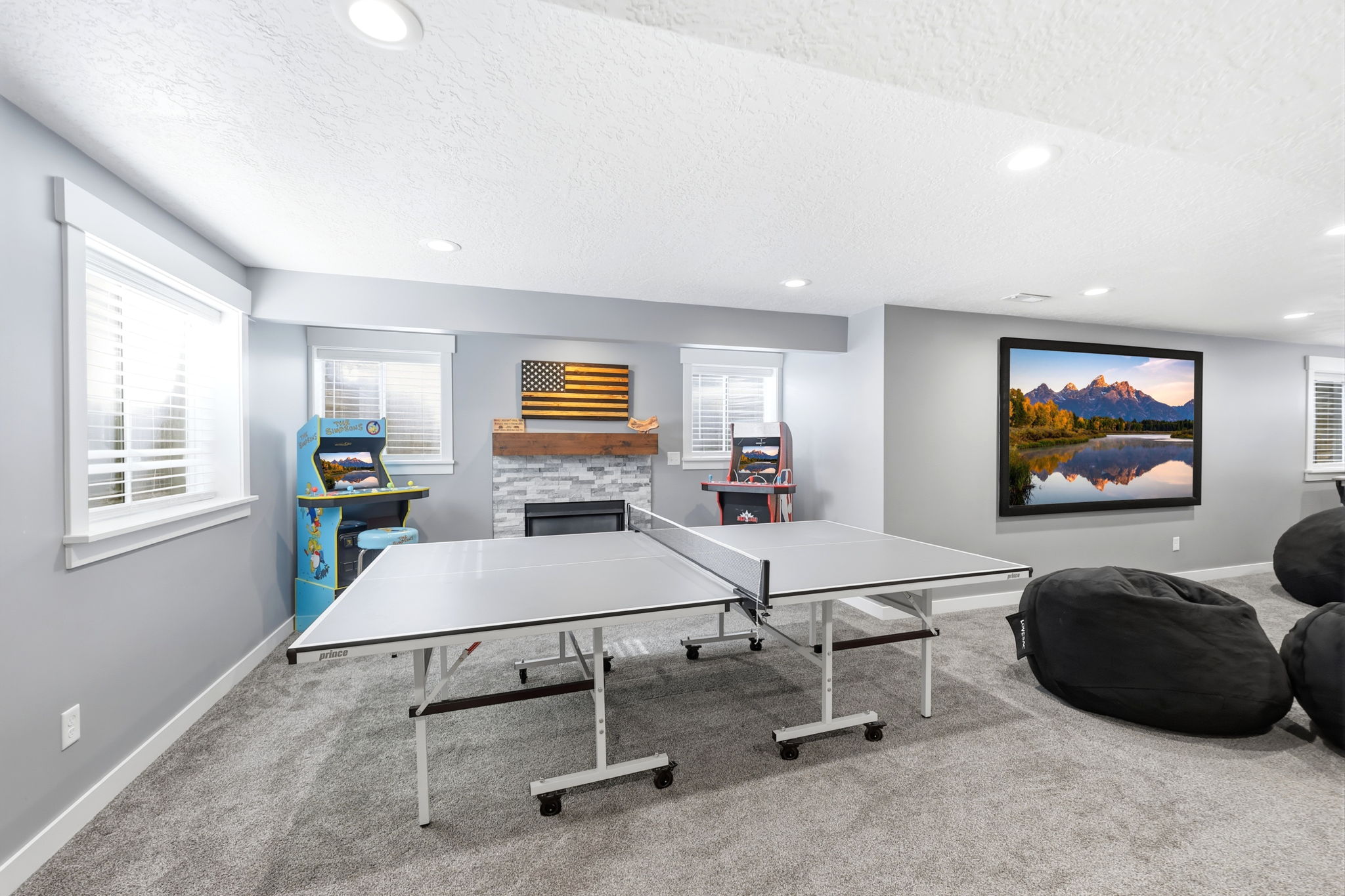 Spacious room featuring light gray walls, recessed lighting, and soft gray carpeting