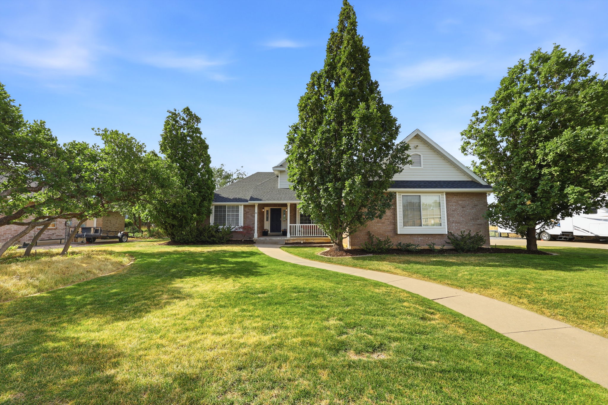 Traditional brick and siding exterior with a dark shingle roof