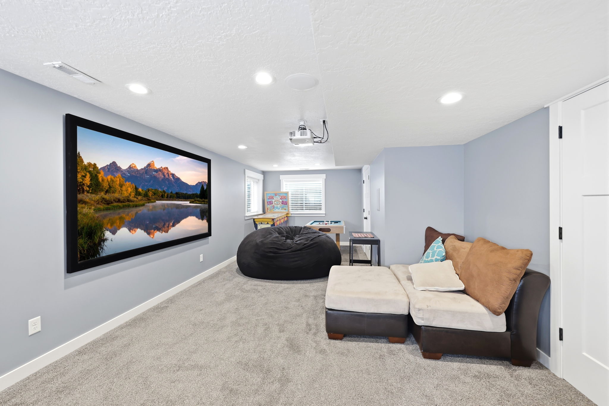 Dedicated media room featuring a large projection screen and ceiling-mounted projector