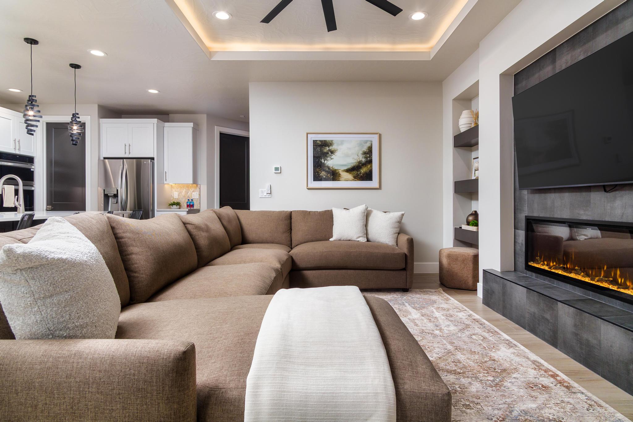 Living area featuring an electric fireplace with a dark tile surround, built-in shelving, and recessed lighting