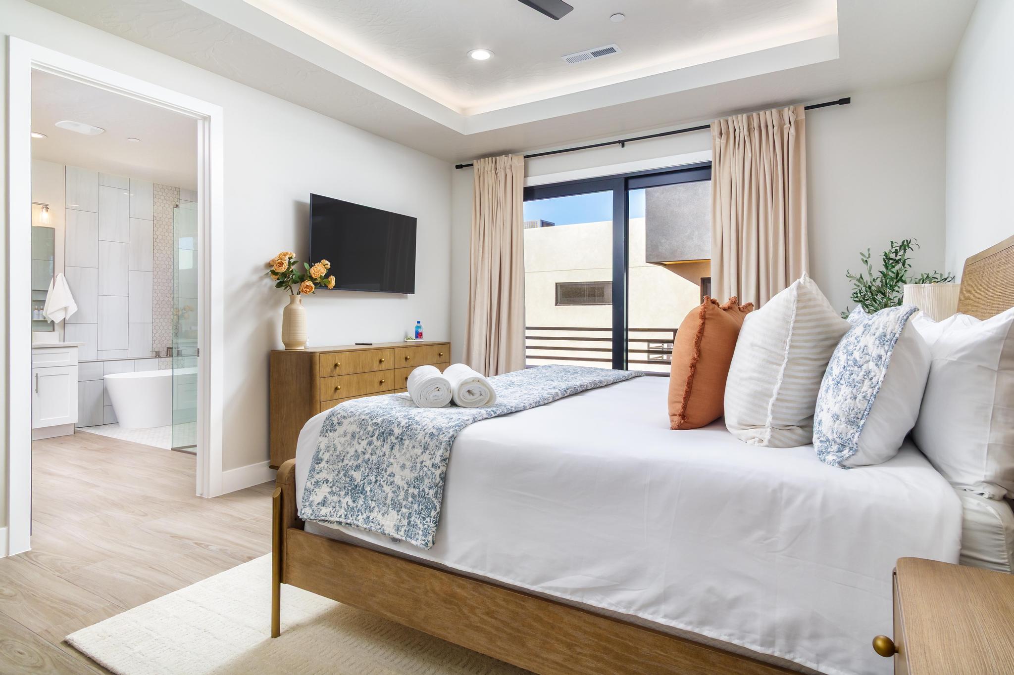Bedroom featuring wood-finish flooring, a tray ceiling with recessed lighting, and a built-in ceiling fan