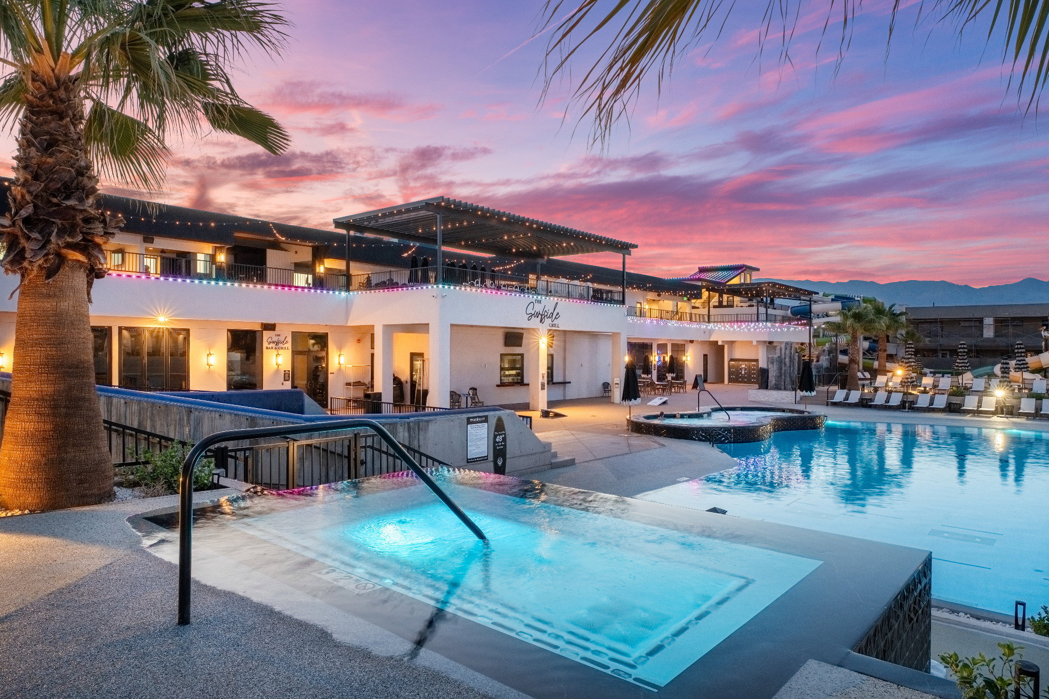 Expansive outdoor area featuring multiple pools, spa, and illuminated patio spaces