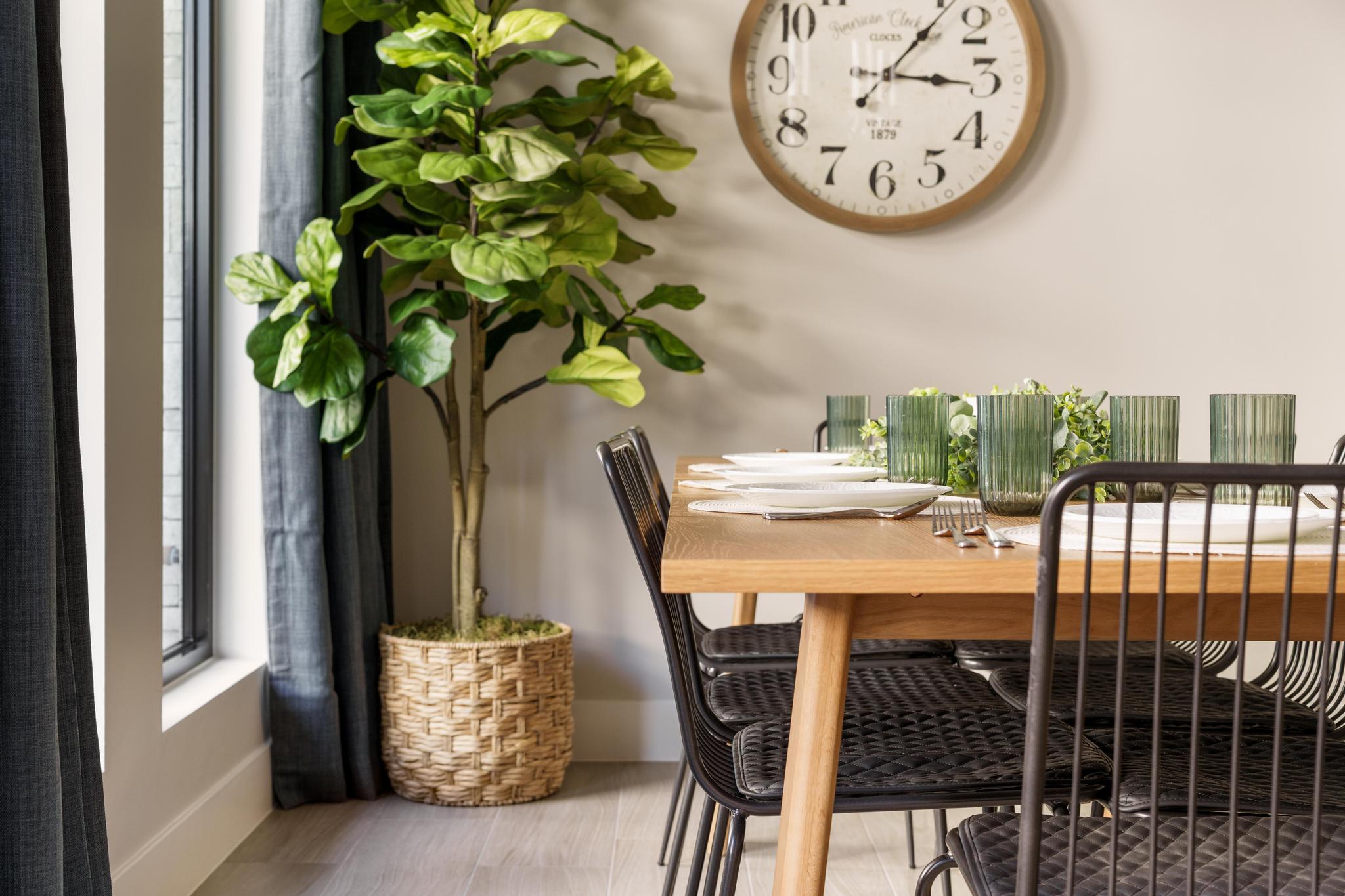 Dining area featuring wood-finish flooring, a light wood dining table, and dark gray window treatments