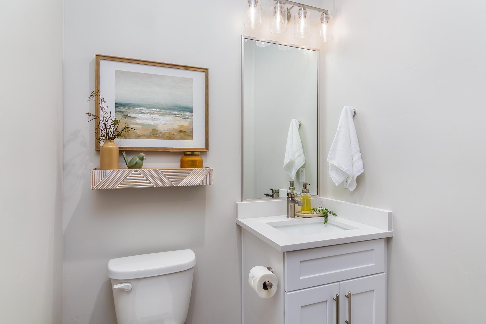 Bathroom featuring a single vanity with white cabinetry, integrated sink, and brushed nickel faucet