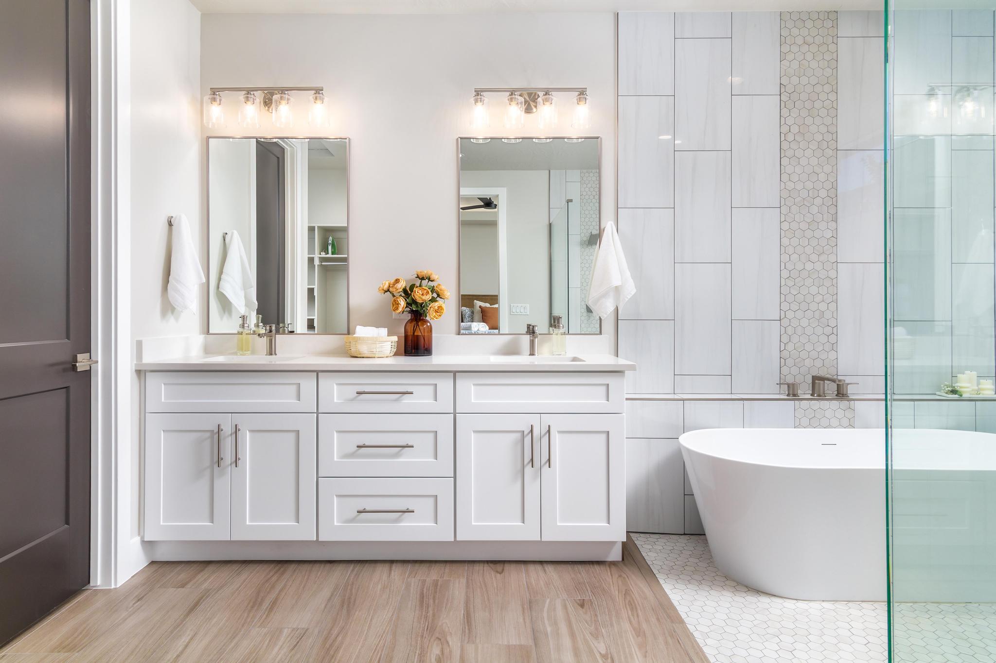 Dual vanity with white cabinetry, brushed nickel hardware, and a light-colored countertop