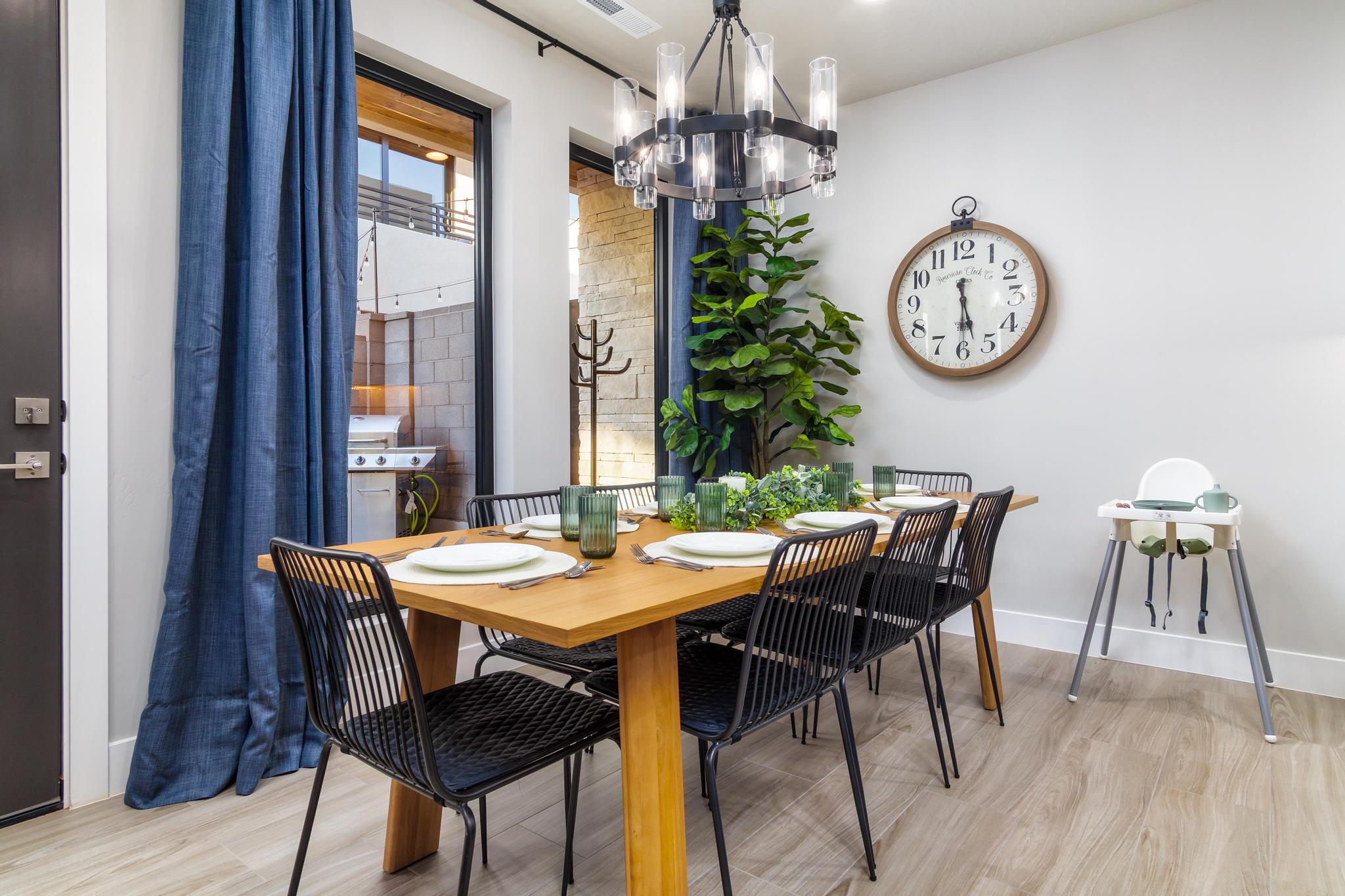 Dining area featuring a contemporary chandelier, wood-finish flooring, and a large glass door providing outdoor access