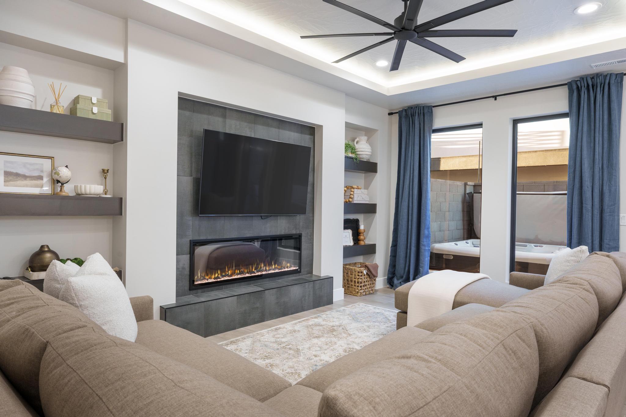 Contemporary living space featuring a tiled accent wall with an integrated electric fireplace