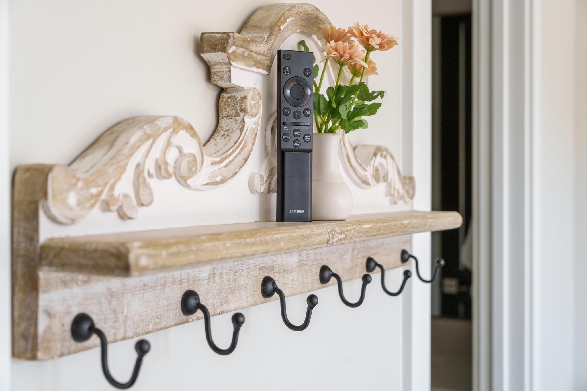 Distressed wood shelf with decorative corbels and six matte black hooks