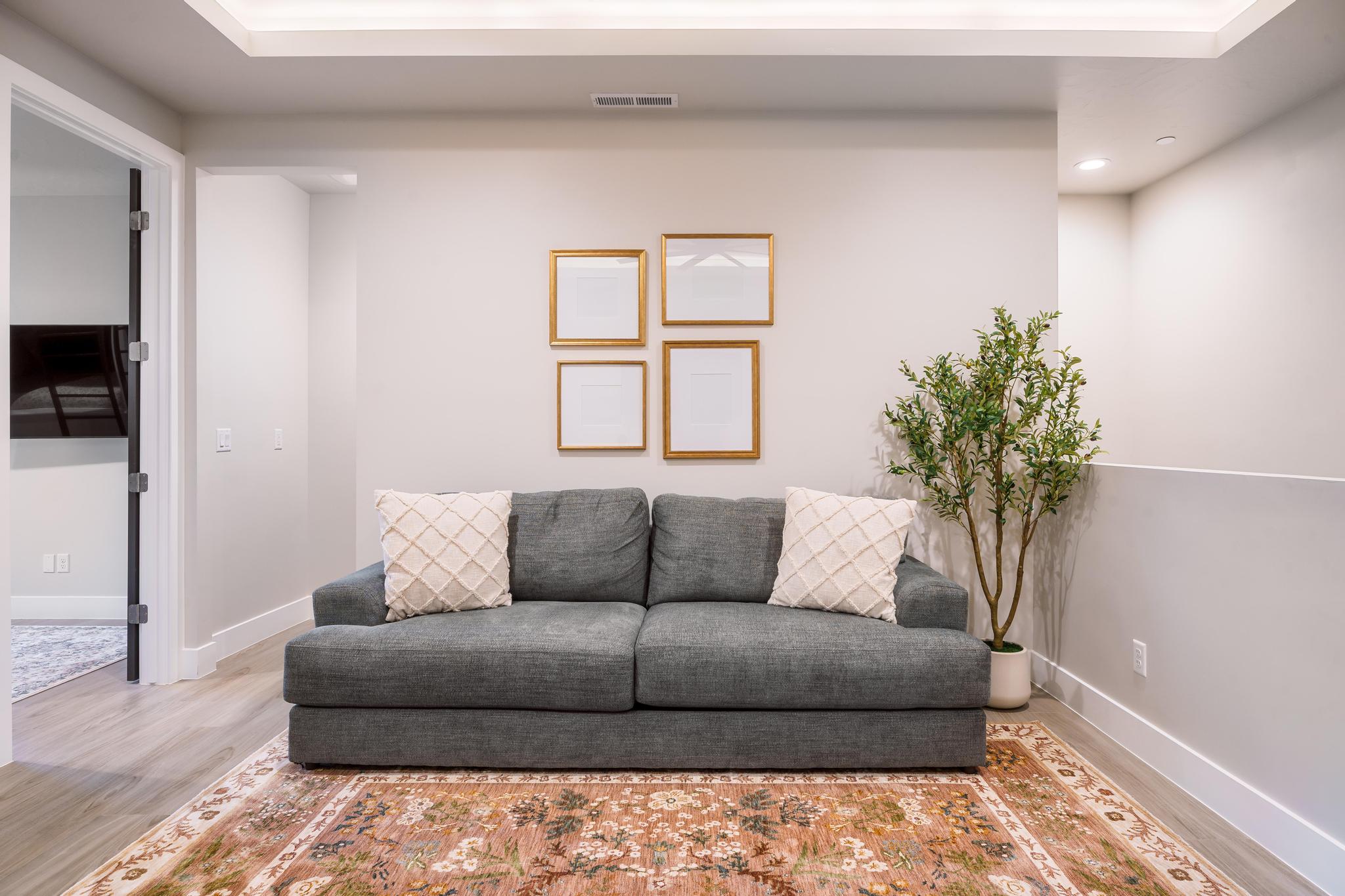 Recessed ceiling with integrated lighting, light wood-finish flooring, and crisp white baseboards