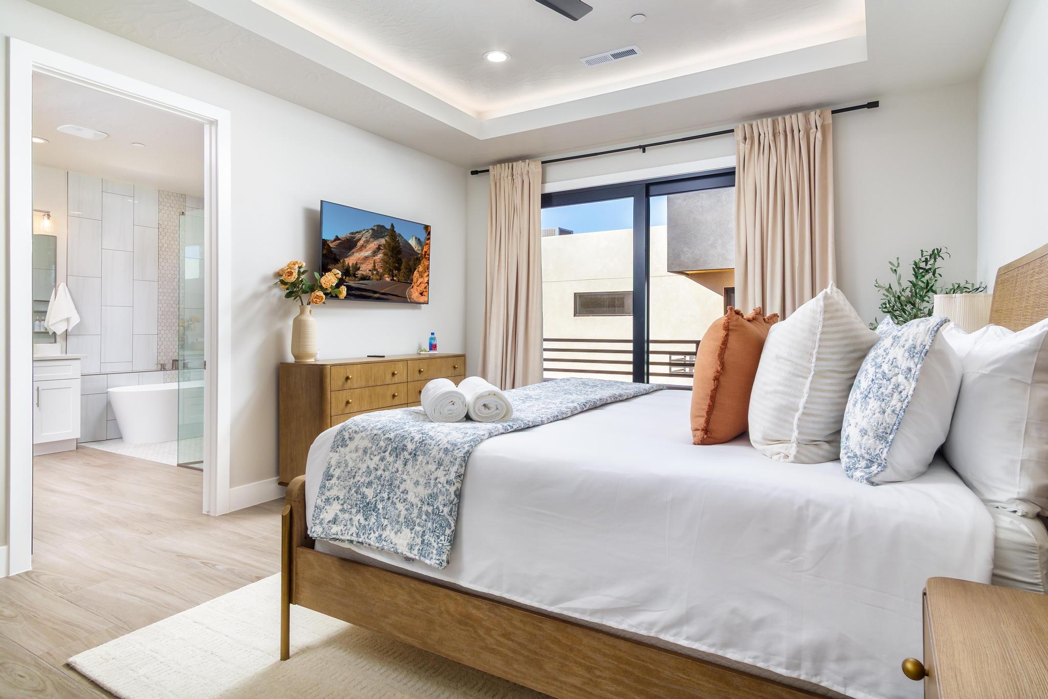 Light wood-finish flooring extending from the bedroom into the full bathroom