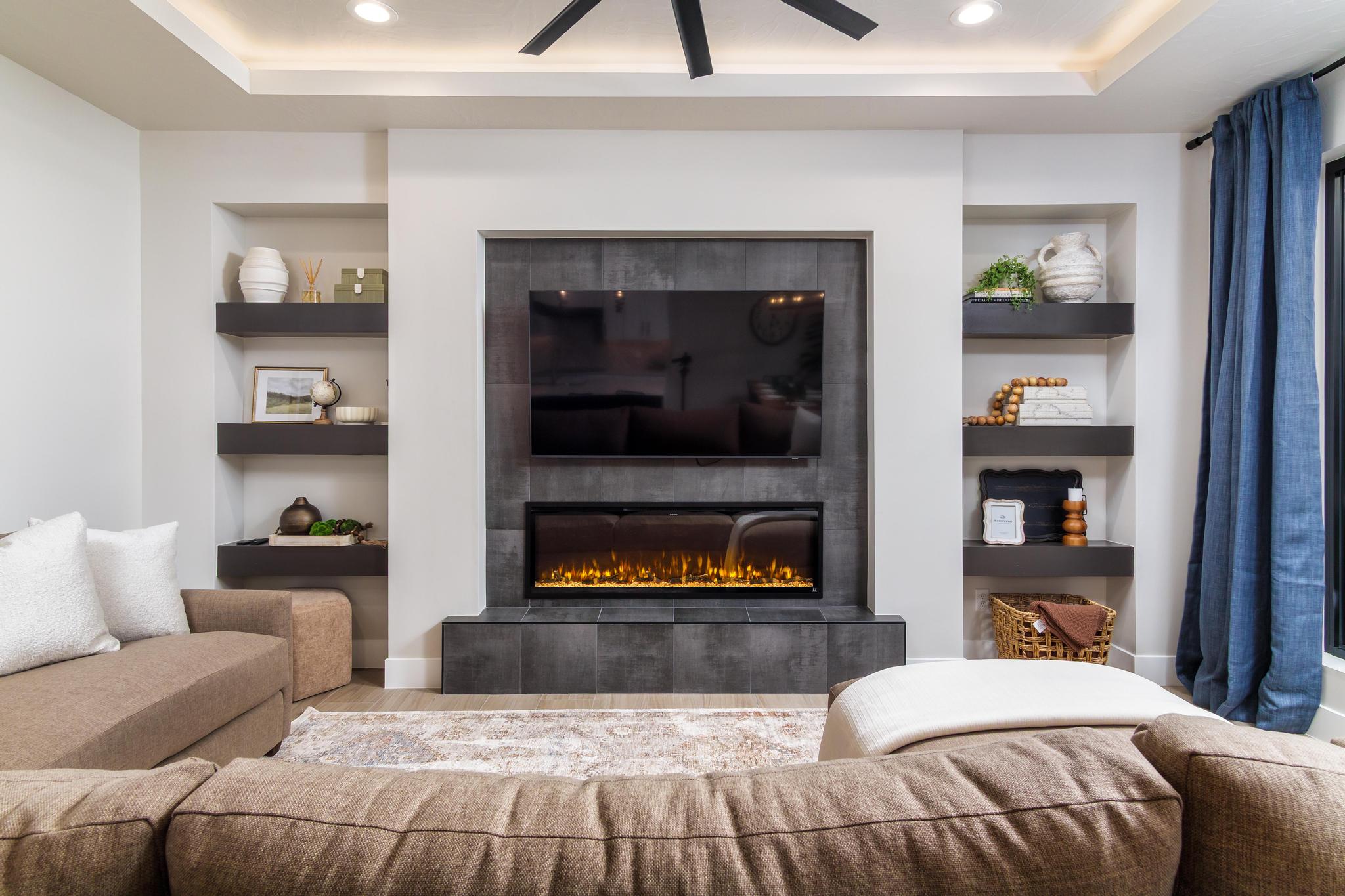 Built-in entertainment wall featuring a mounted television above a linear electric fireplace with a dark tile surround