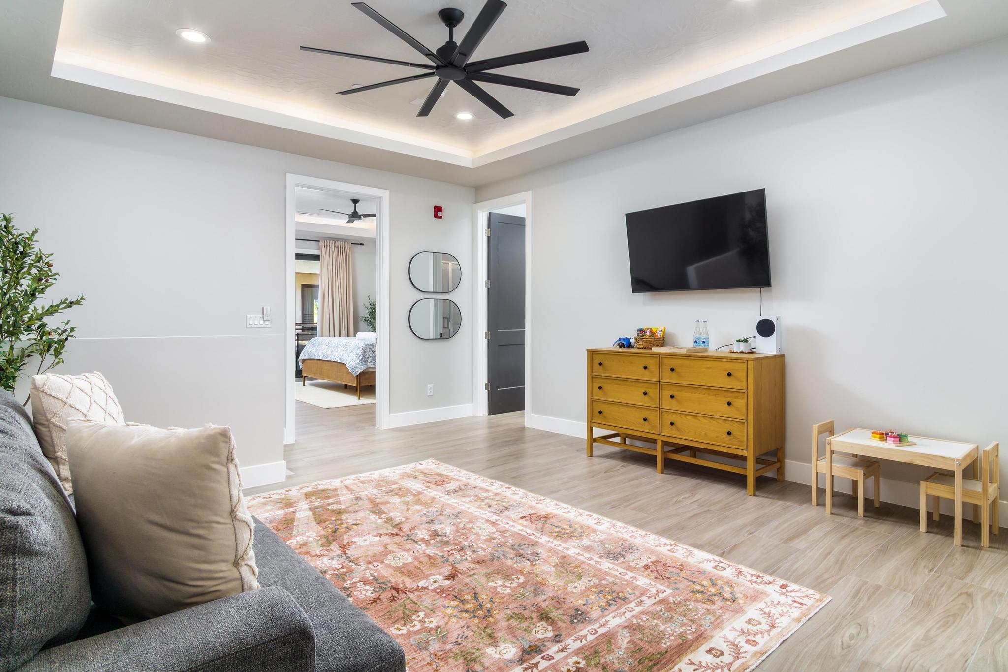 Recessed ceiling with integrated lighting and a contemporary black ceiling fan