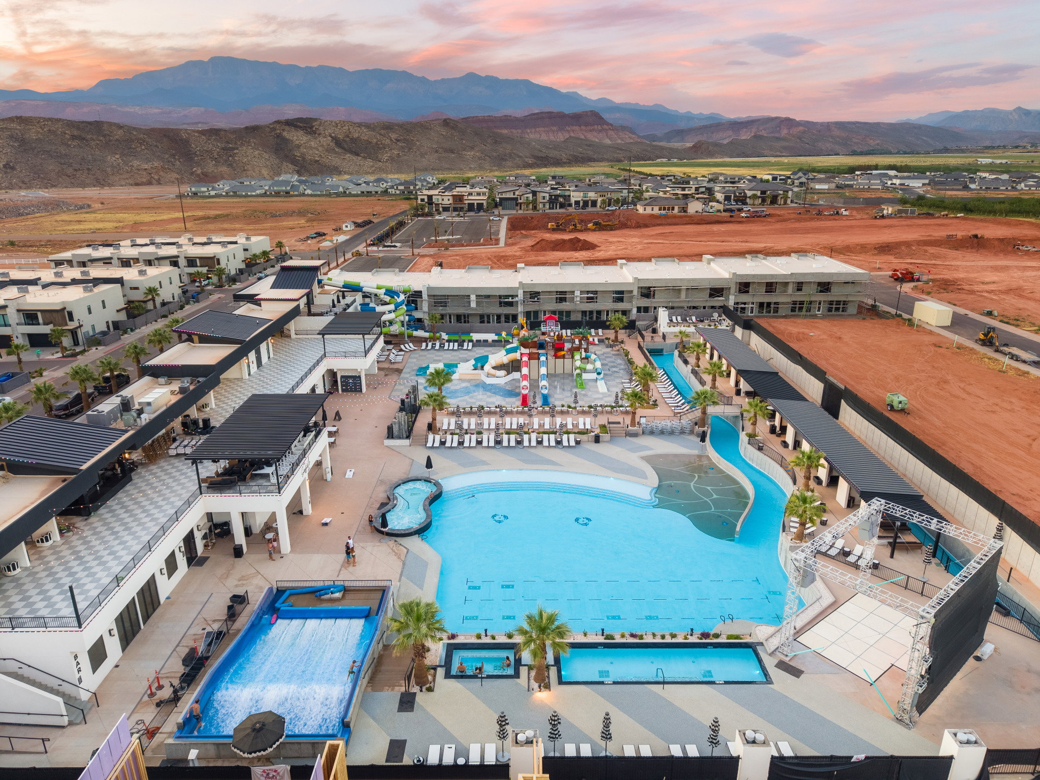 Expansive community amenity area featuring a large central pool, a lazy river, and a surf simulator