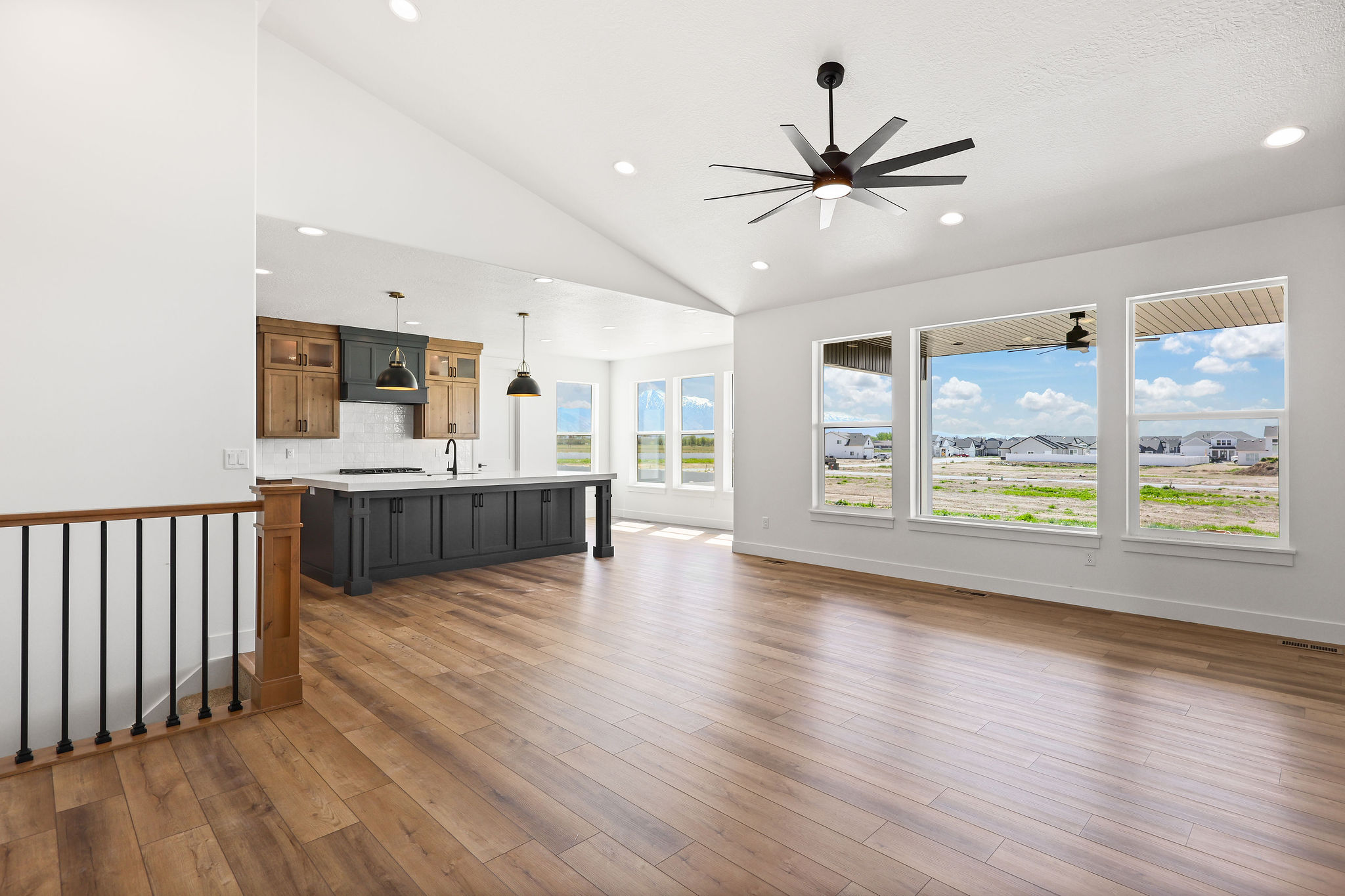 Vaulted ceilings and wood-finish flooring enhance this open-concept space