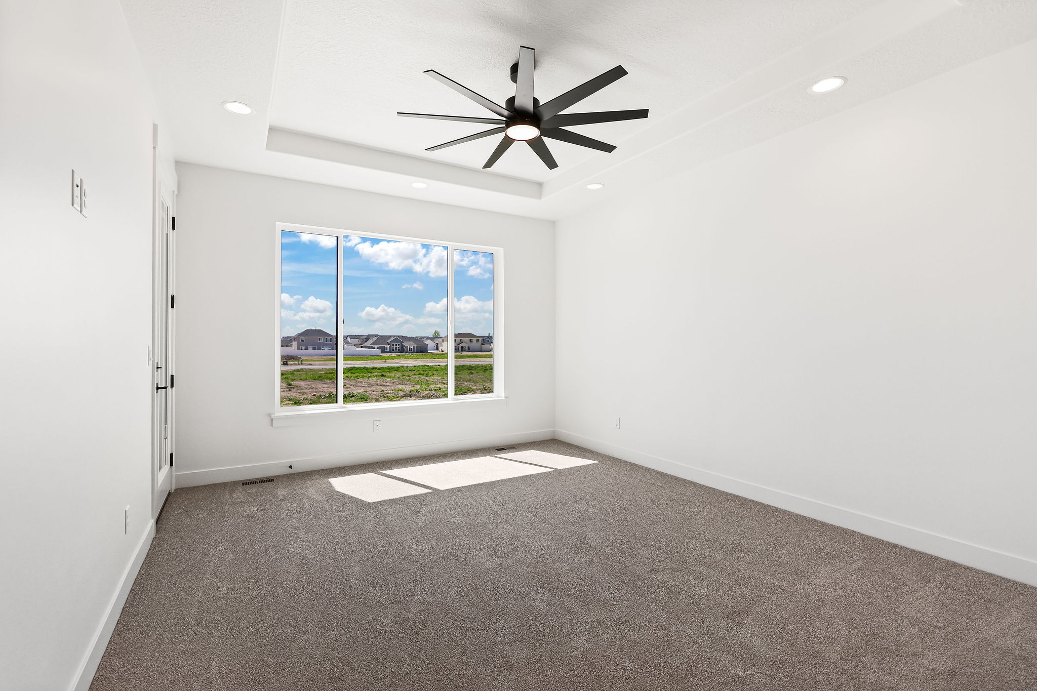Tray ceiling featuring recessed lighting and a black ceiling fan
