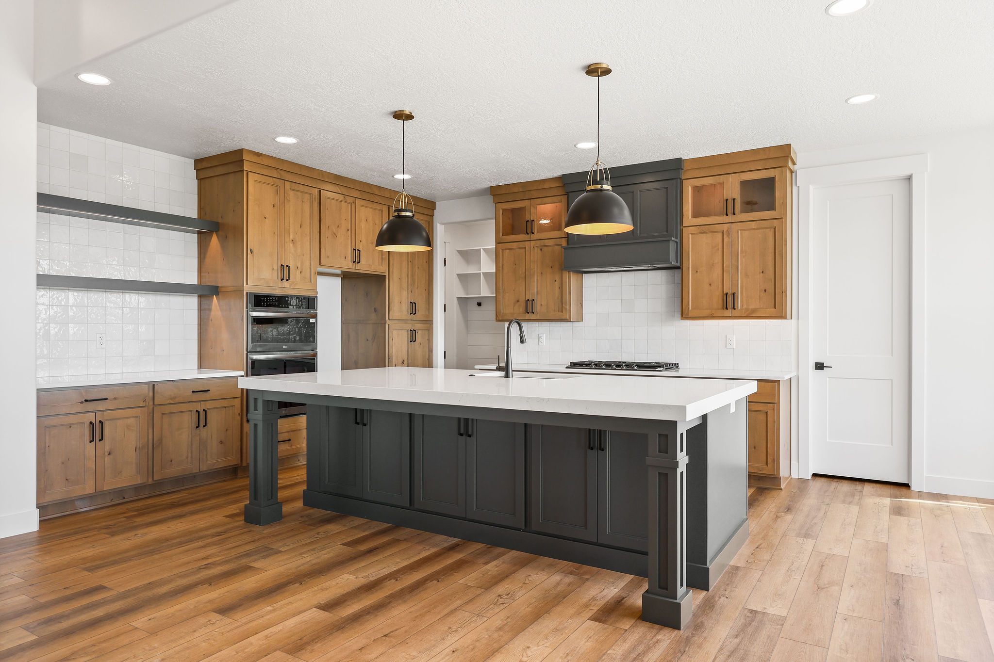 Spacious kitchen featuring a large central island with dark cabinetry and a white countertop