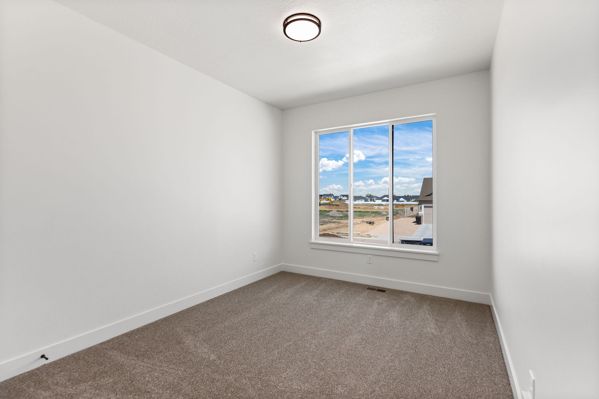 Room with light gray carpeting, white walls, and a large multi-pane window
