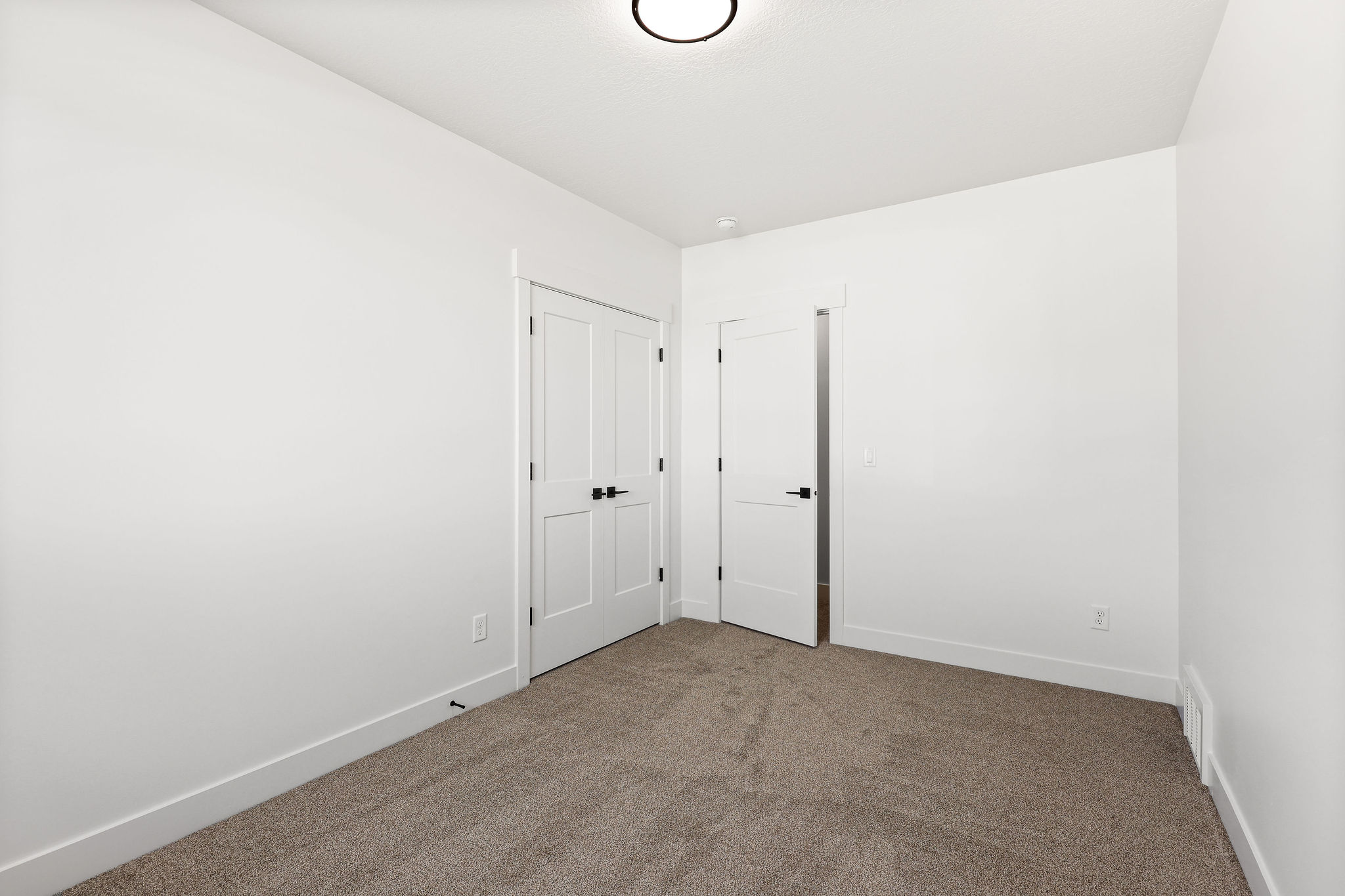 Bright interior space featuring neutral wall paint and plush carpeting