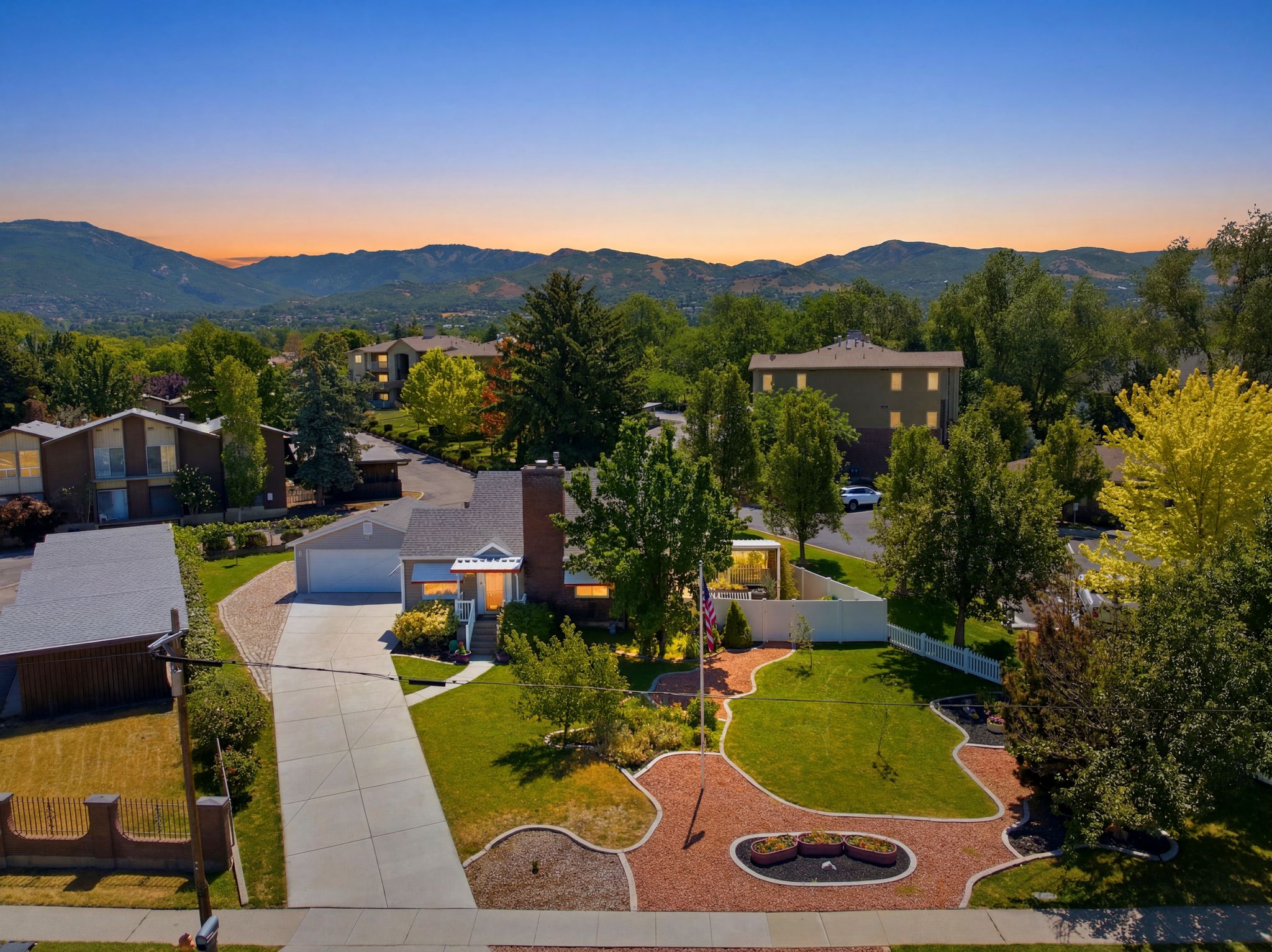 Two-story residence featuring a prominent brick chimney, an attached garage, and a long concrete driveway