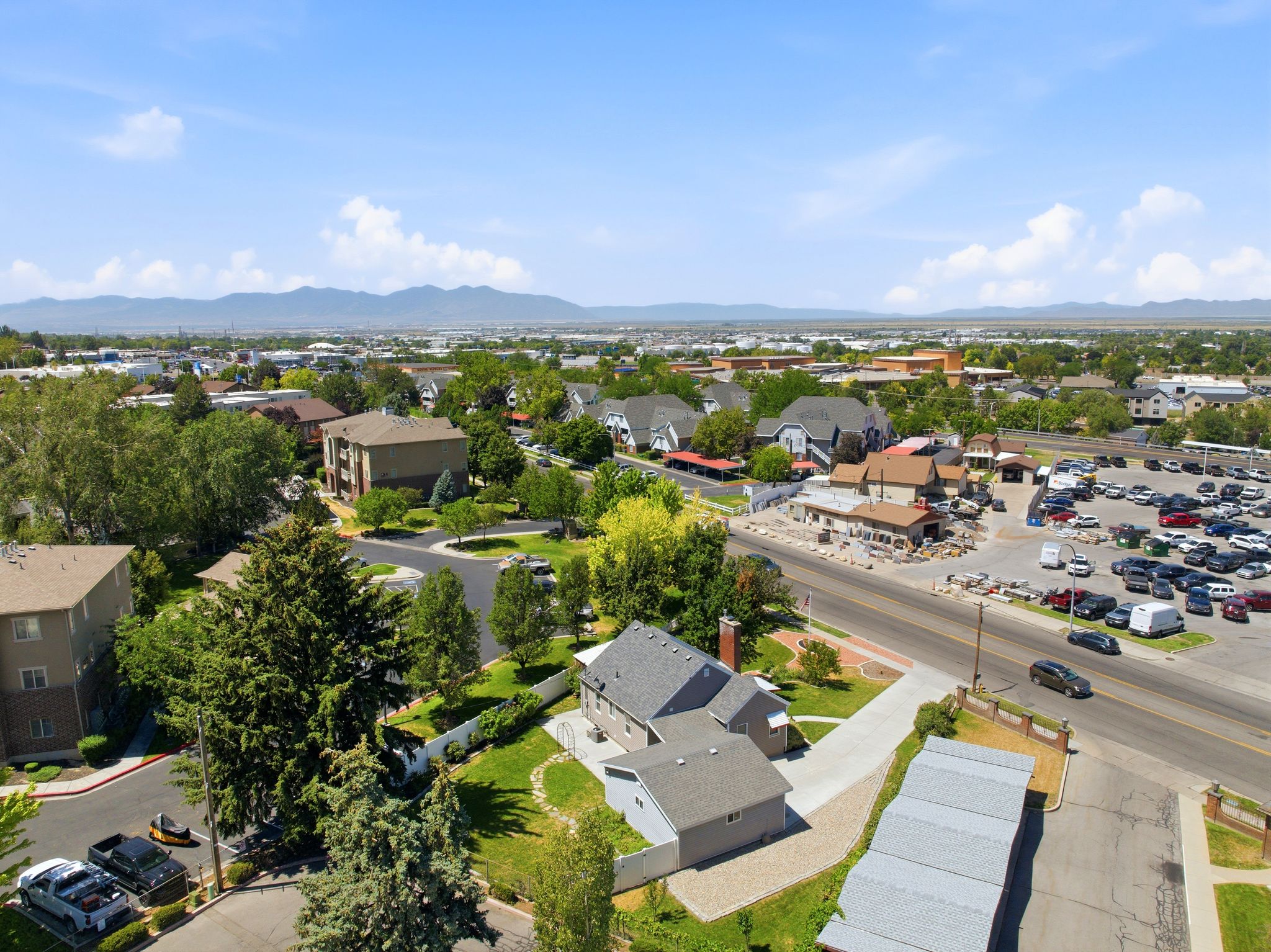 Aerial perspective showcasing the property with a gray shingle roof and a concrete driveway