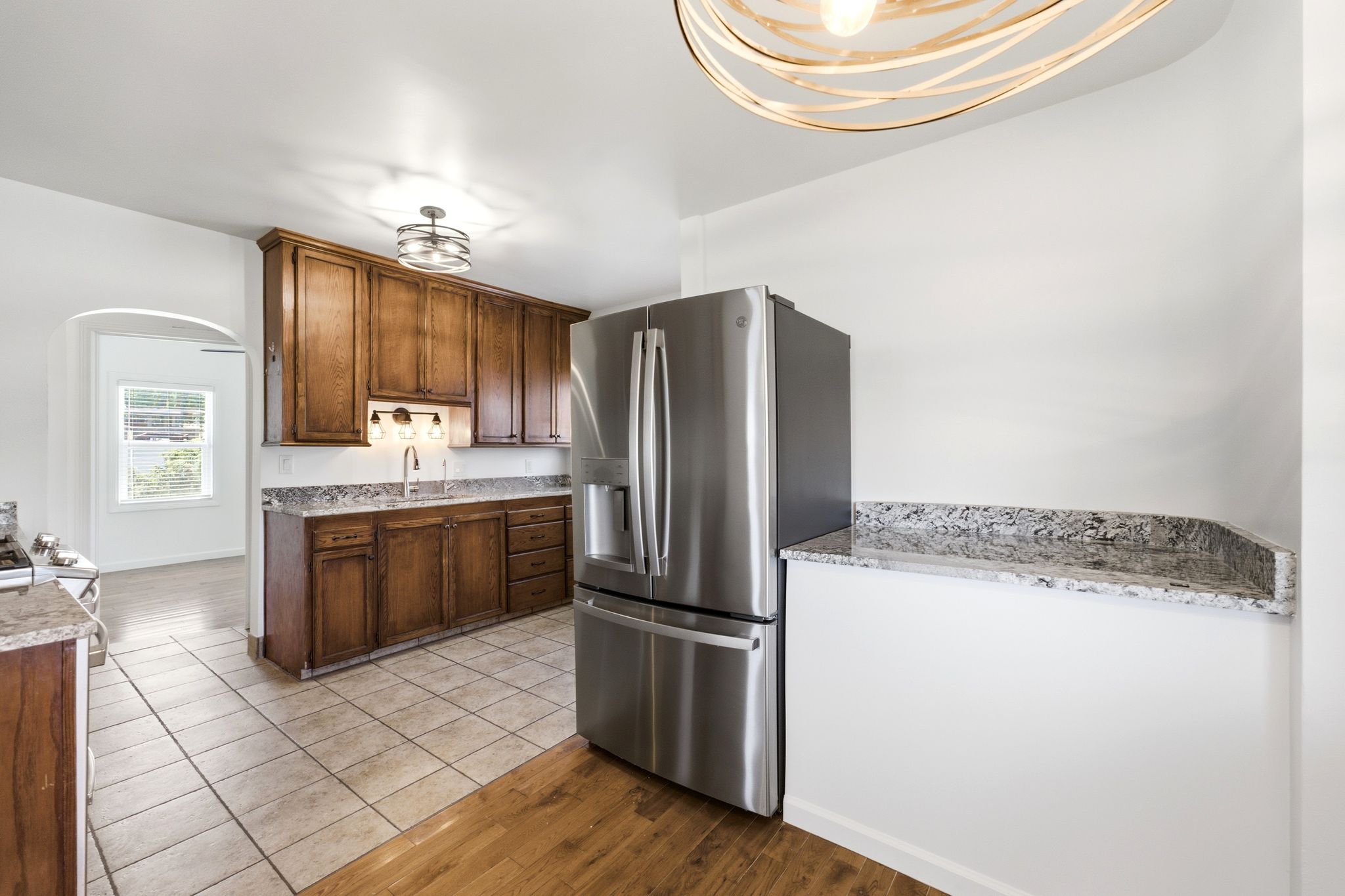 Kitchen featuring wood cabinetry, stainless steel refrigerator, and granite countertops