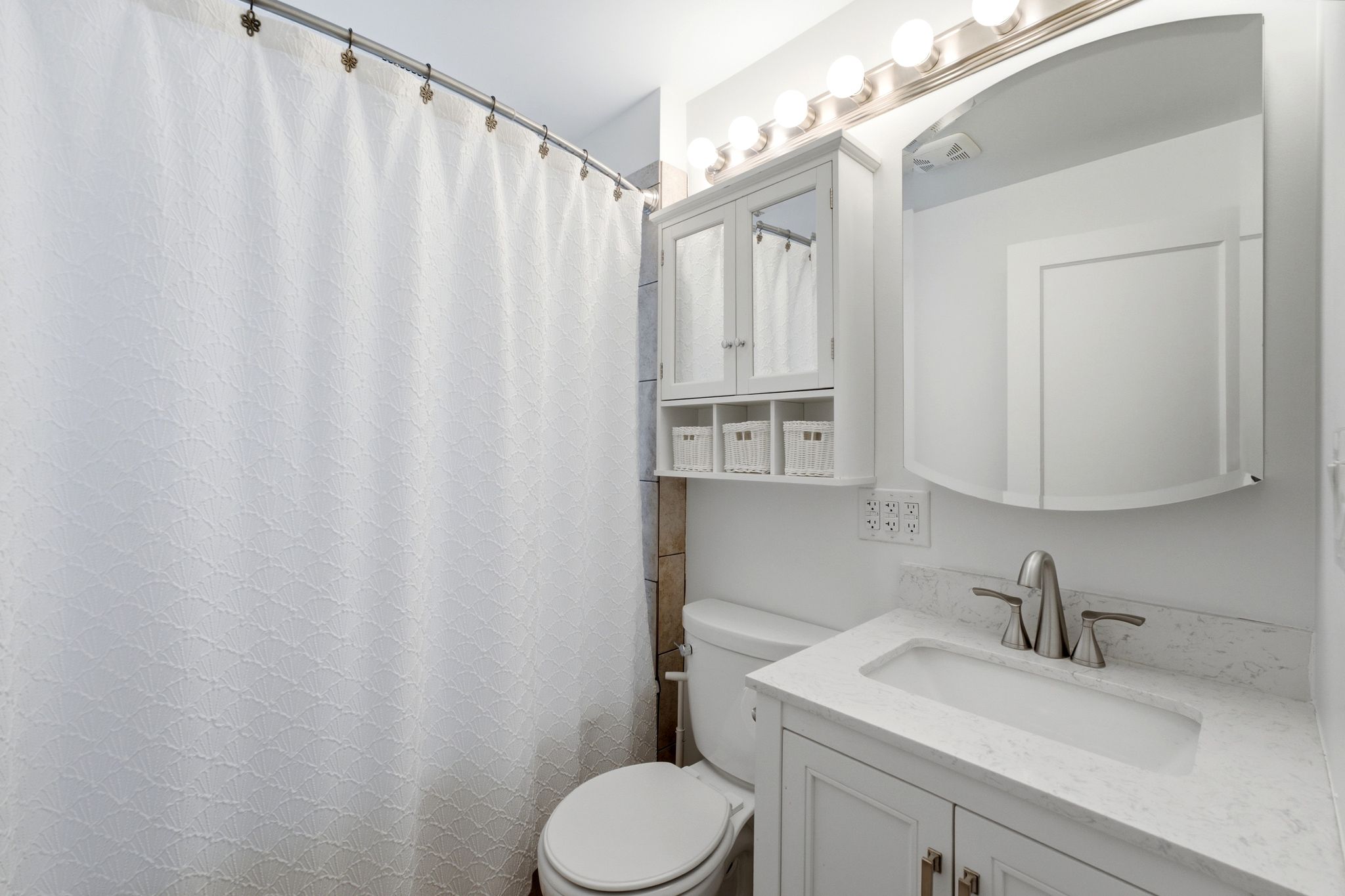 Bathroom featuring a white vanity with a light-colored countertop, an undermount sink, and brushed nickel fixtures