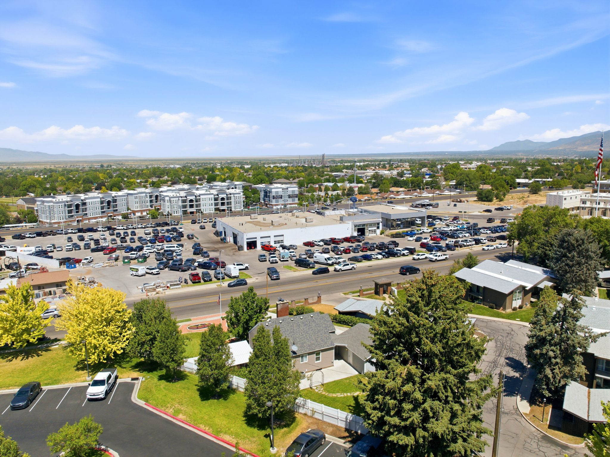 Expansive aerial view showcasing a commercial district with multiple buildings and extensive parking areas