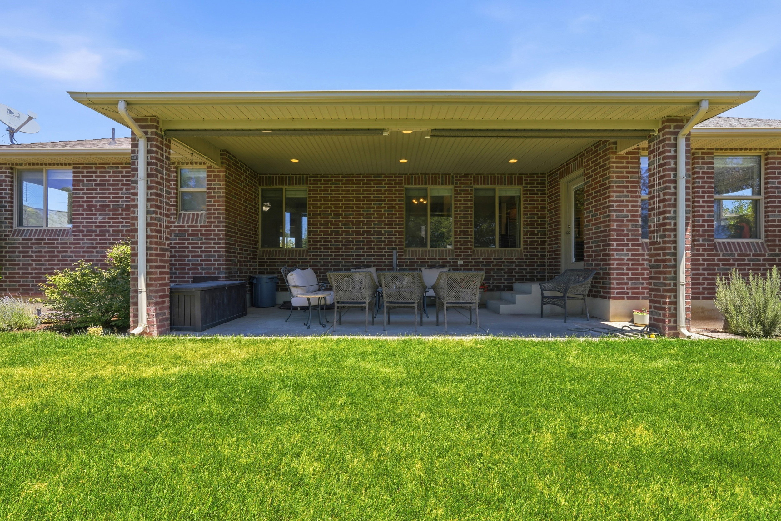 Expansive covered patio featuring brick exterior walls and recessed lighting