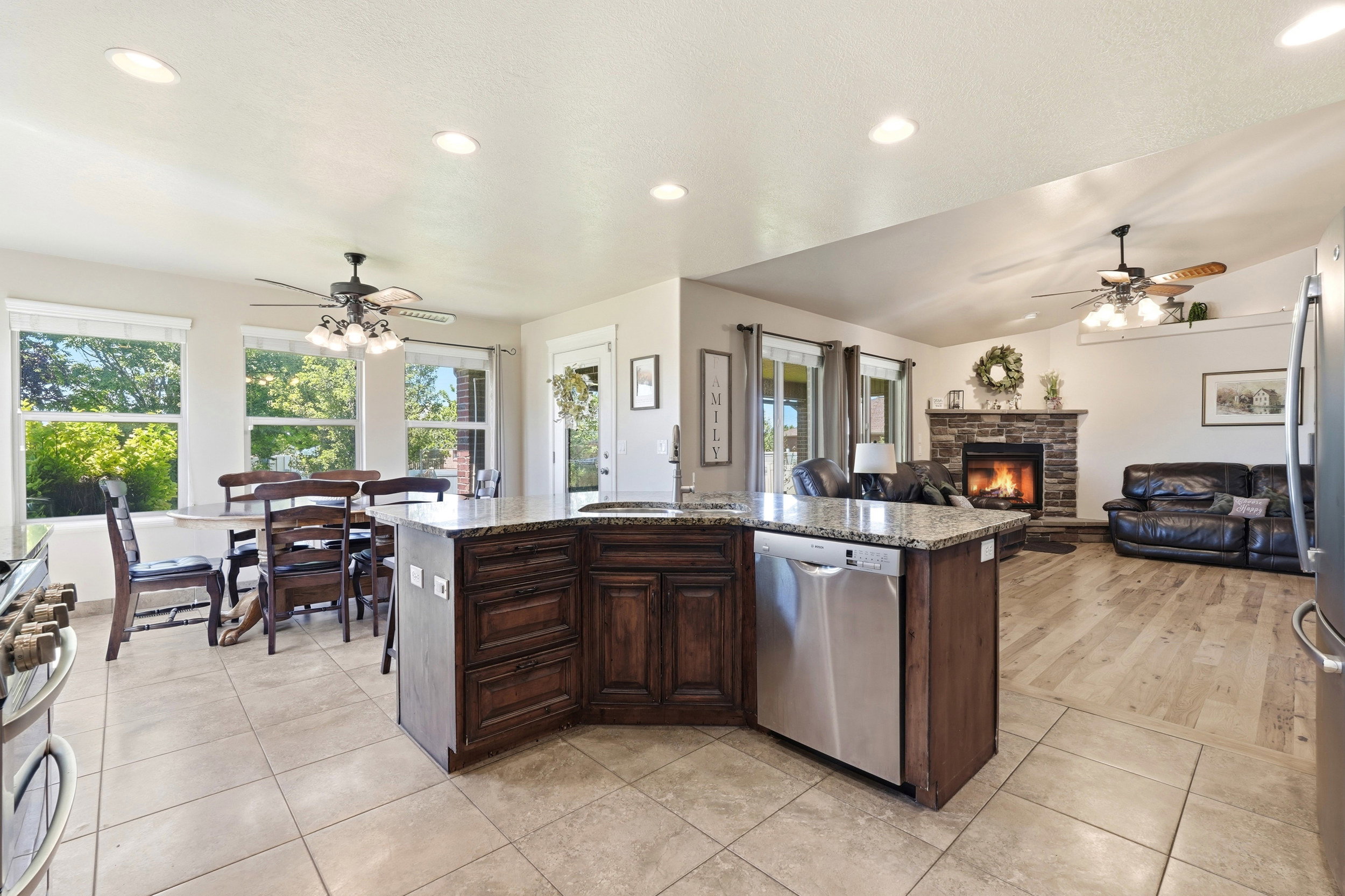 Kitchen island with granite-finish countertop and dark wood-finish cabinetry