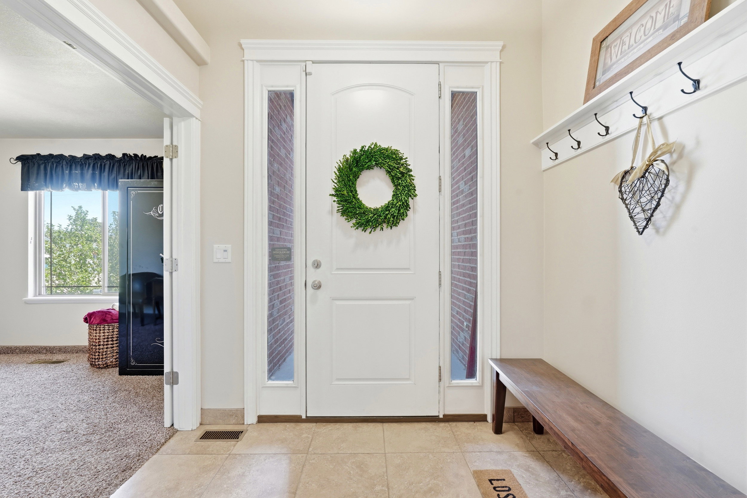 Entryway featuring a white paneled door with sidelights, transom window, and tiled flooring