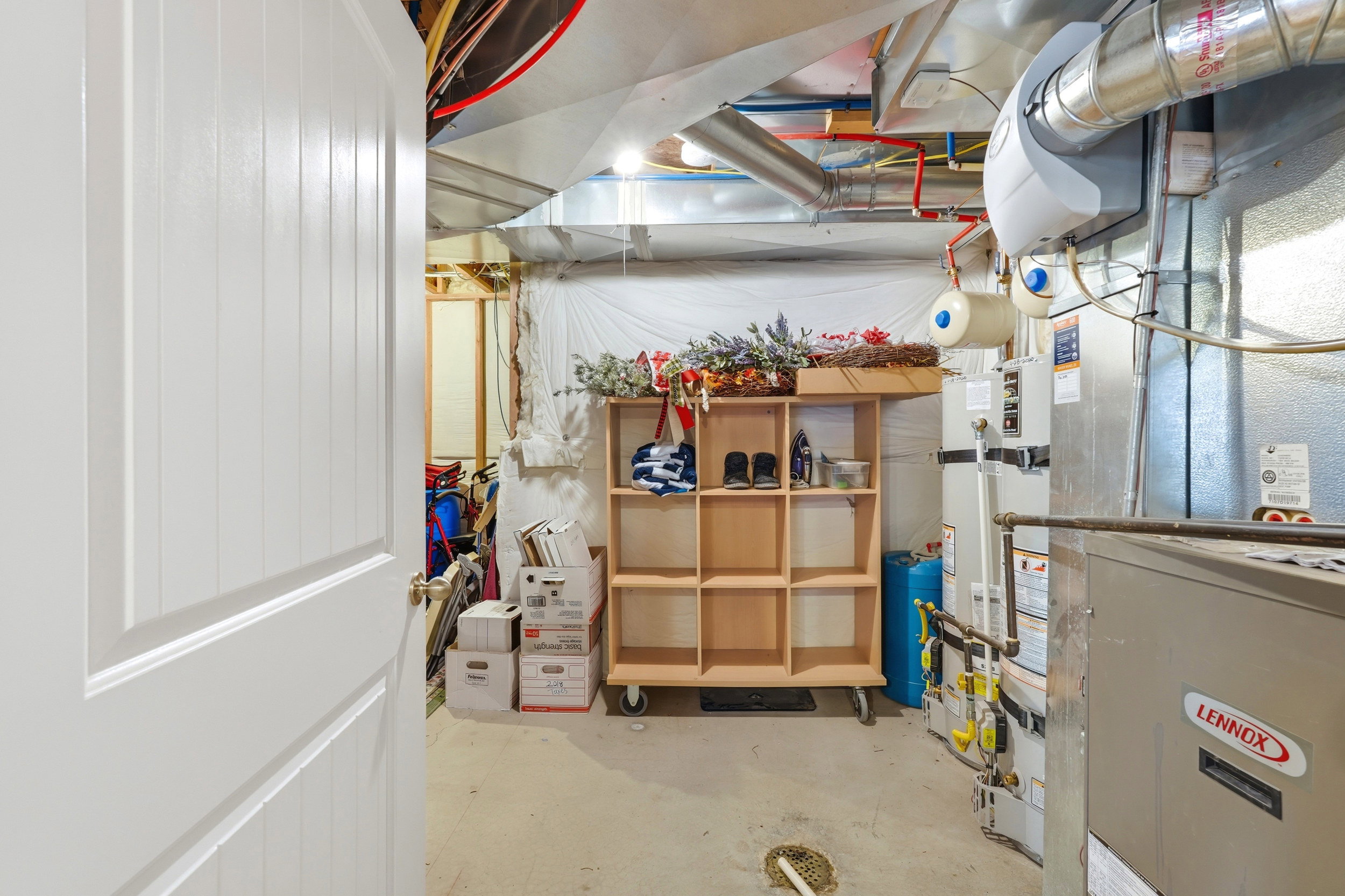 Utility room featuring a Lennox furnace system, exposed ductwork, and overhead plumbing