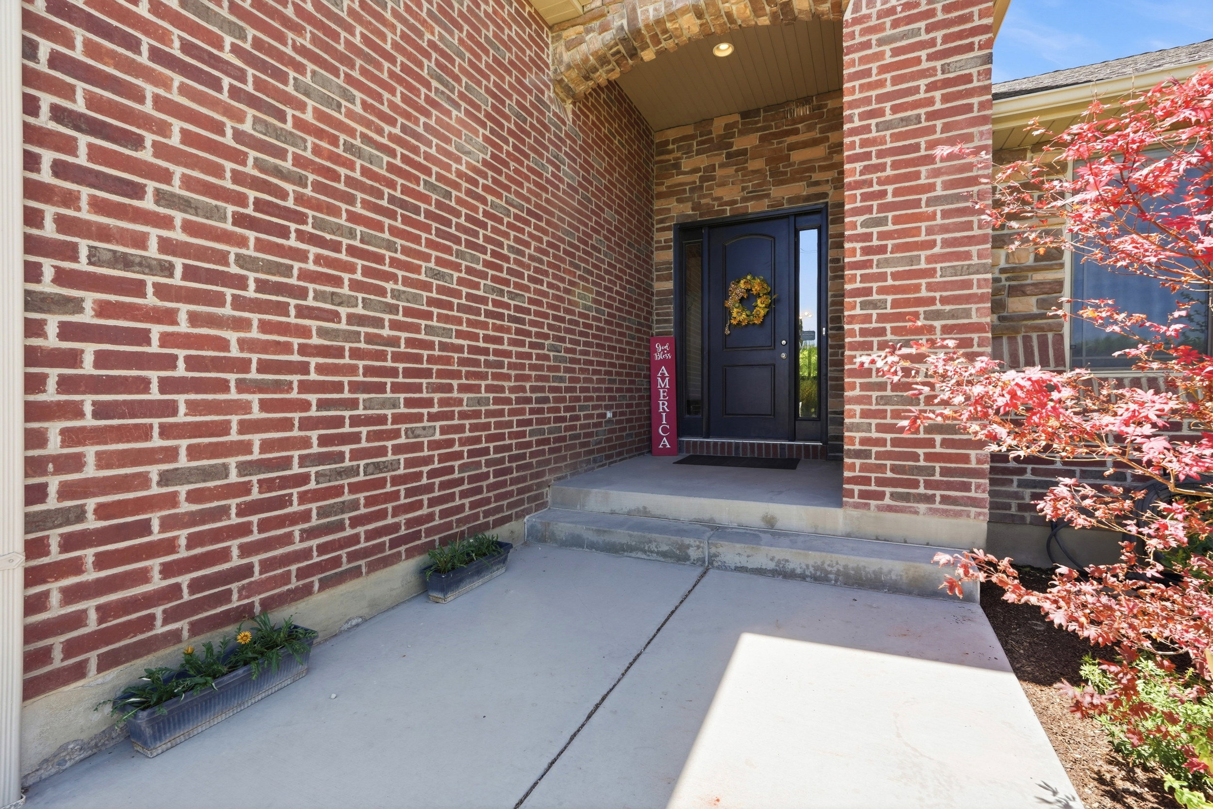 Brick exterior with an arched entryway and a dark-paneled front door