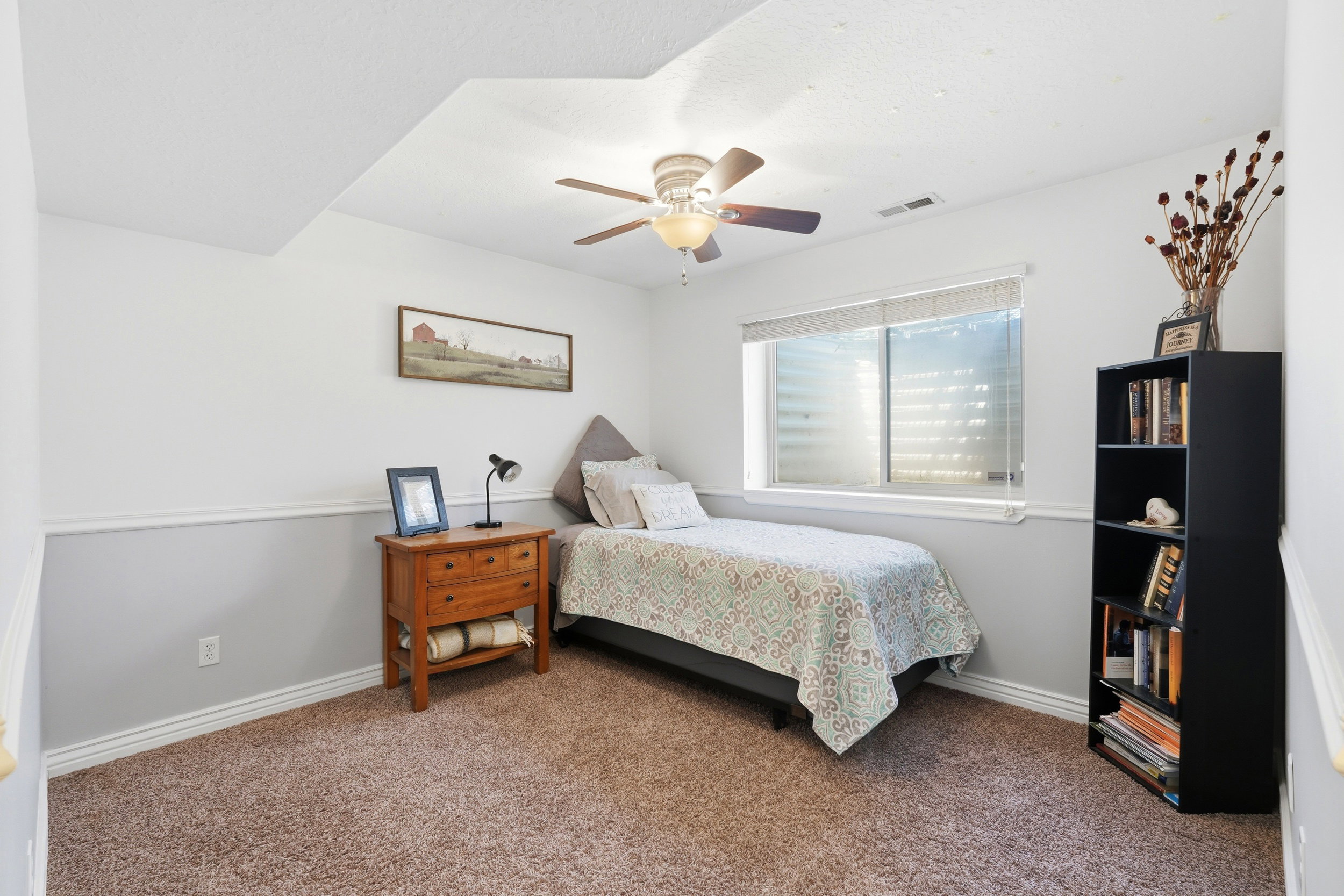 Bedroom featuring wall-to-wall carpeting, a multi-pane window with blinds, and a ceiling fan with integrated lighting