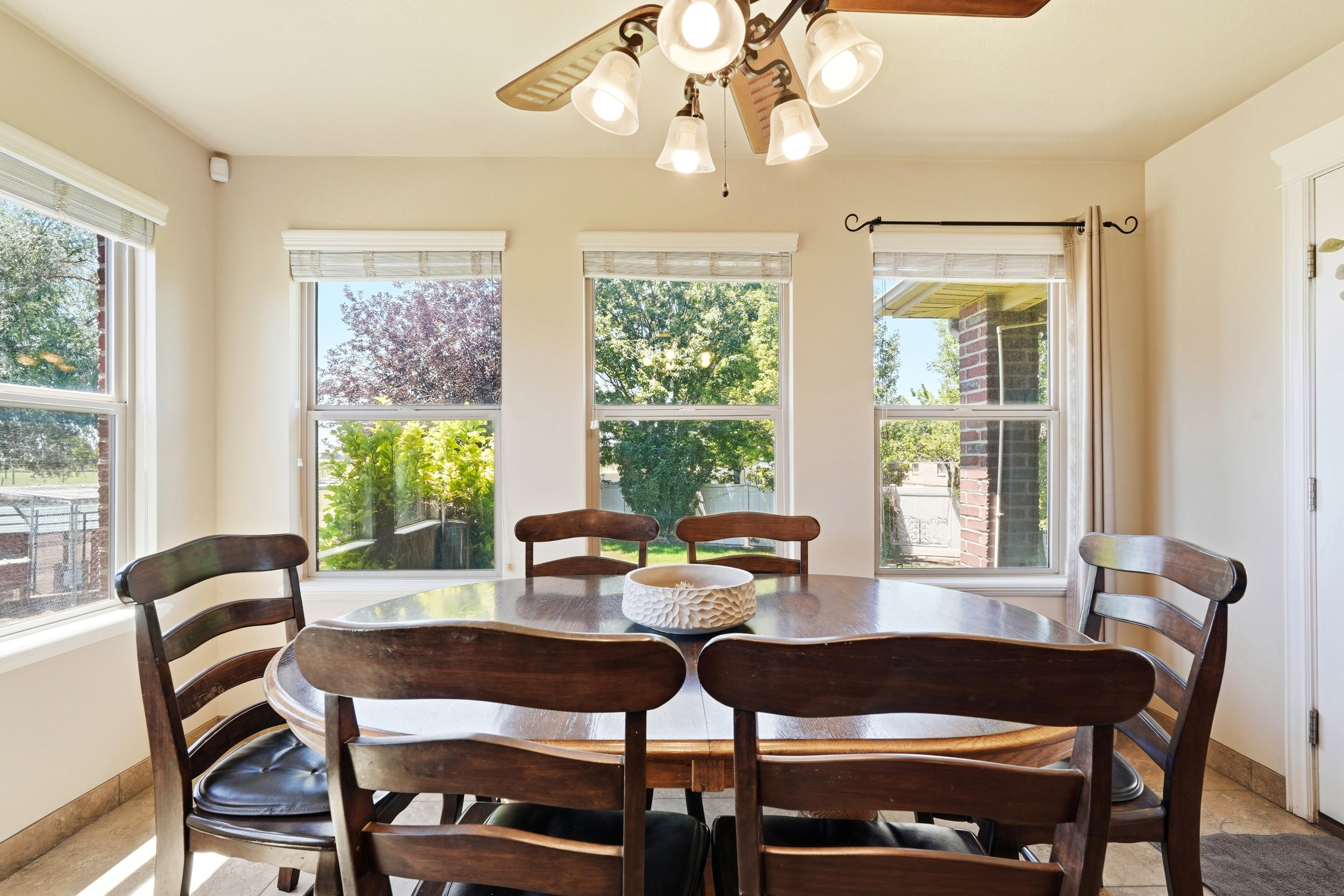 Dining area featuring multiple windows, a ceiling fan with integrated lighting, and tile flooring