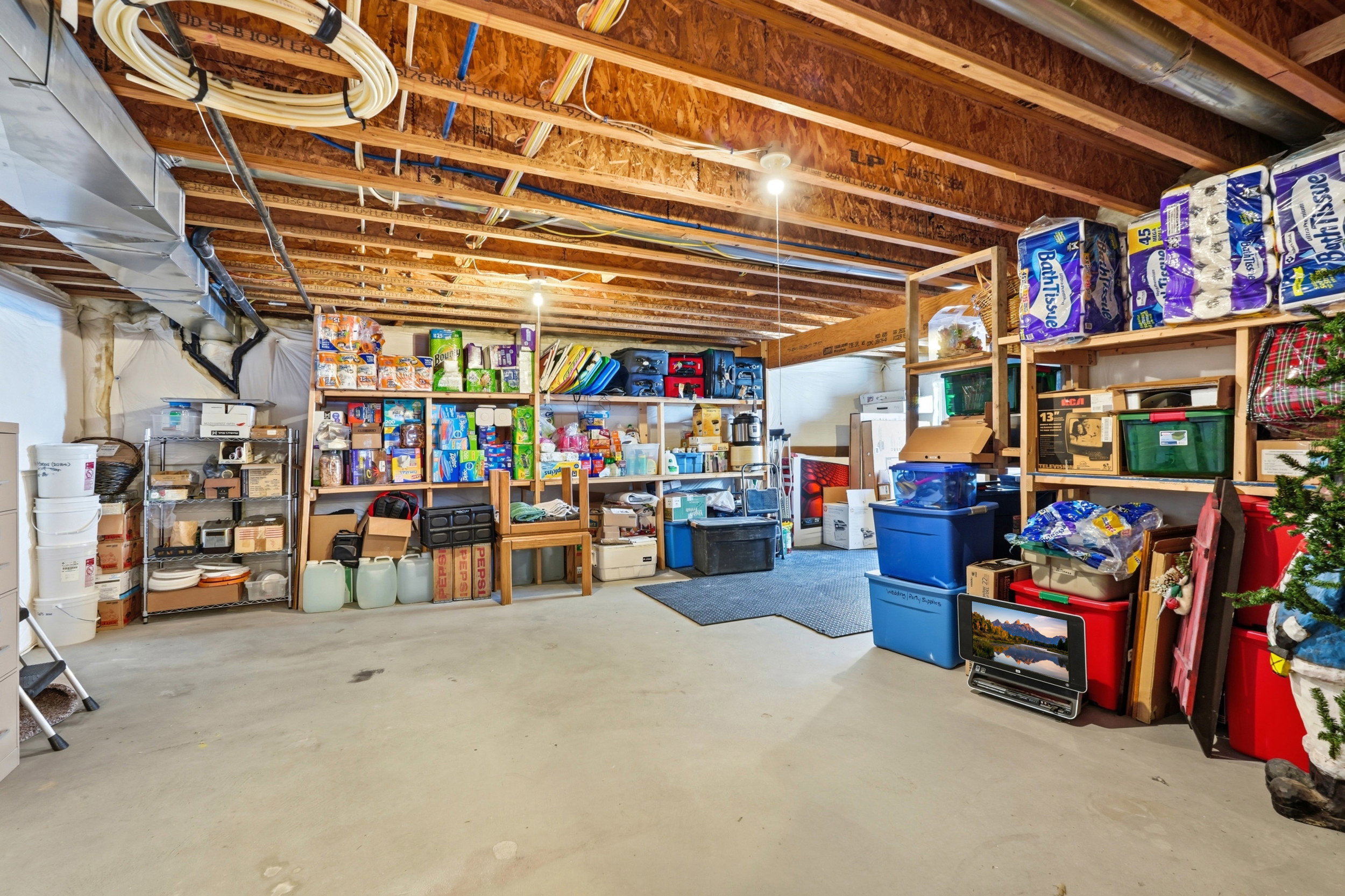 Unfinished basement featuring exposed wood joists and concrete flooring