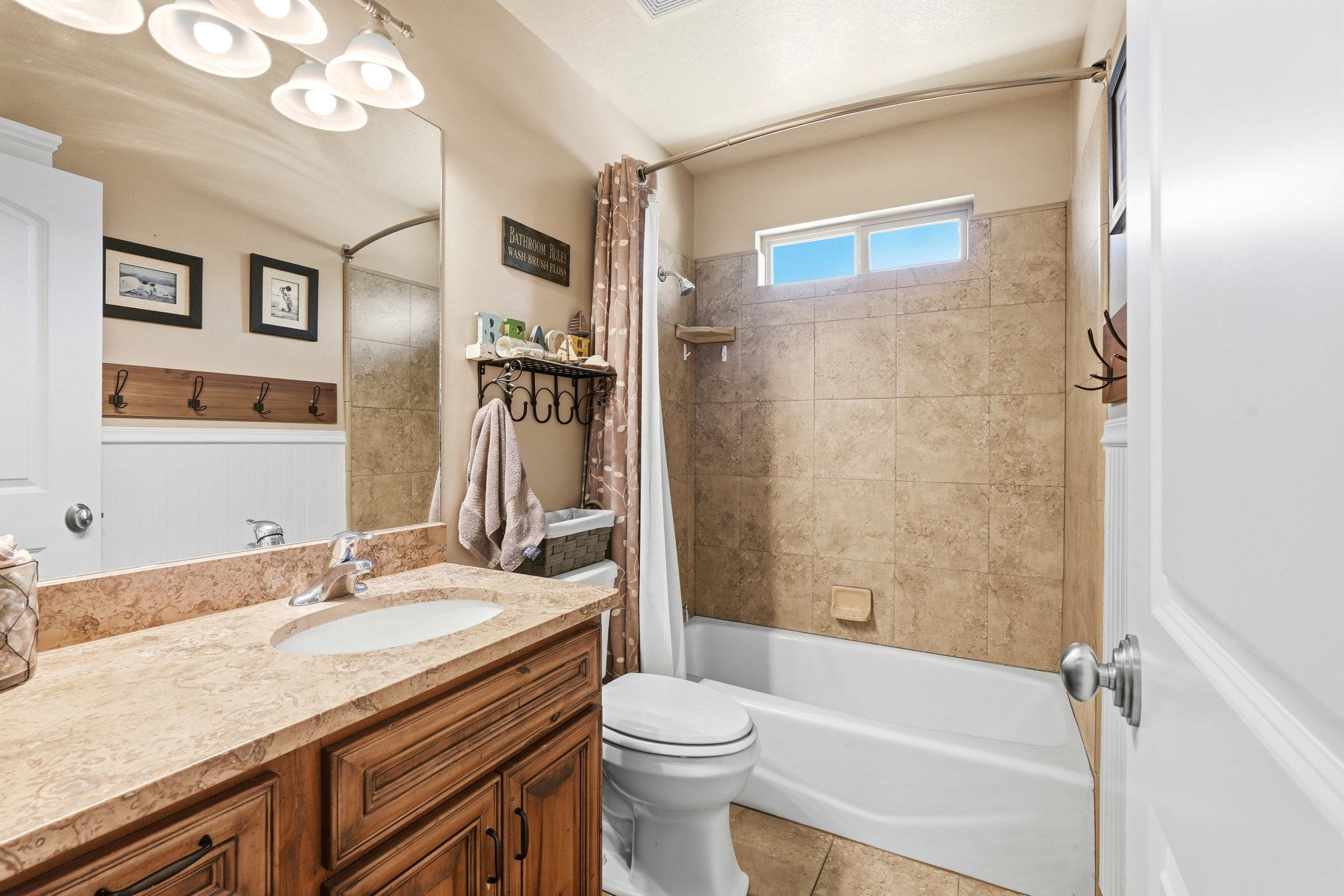 Bathroom featuring a vanity with a light-toned countertop, a single basin sink, and wood-finish cabinetry