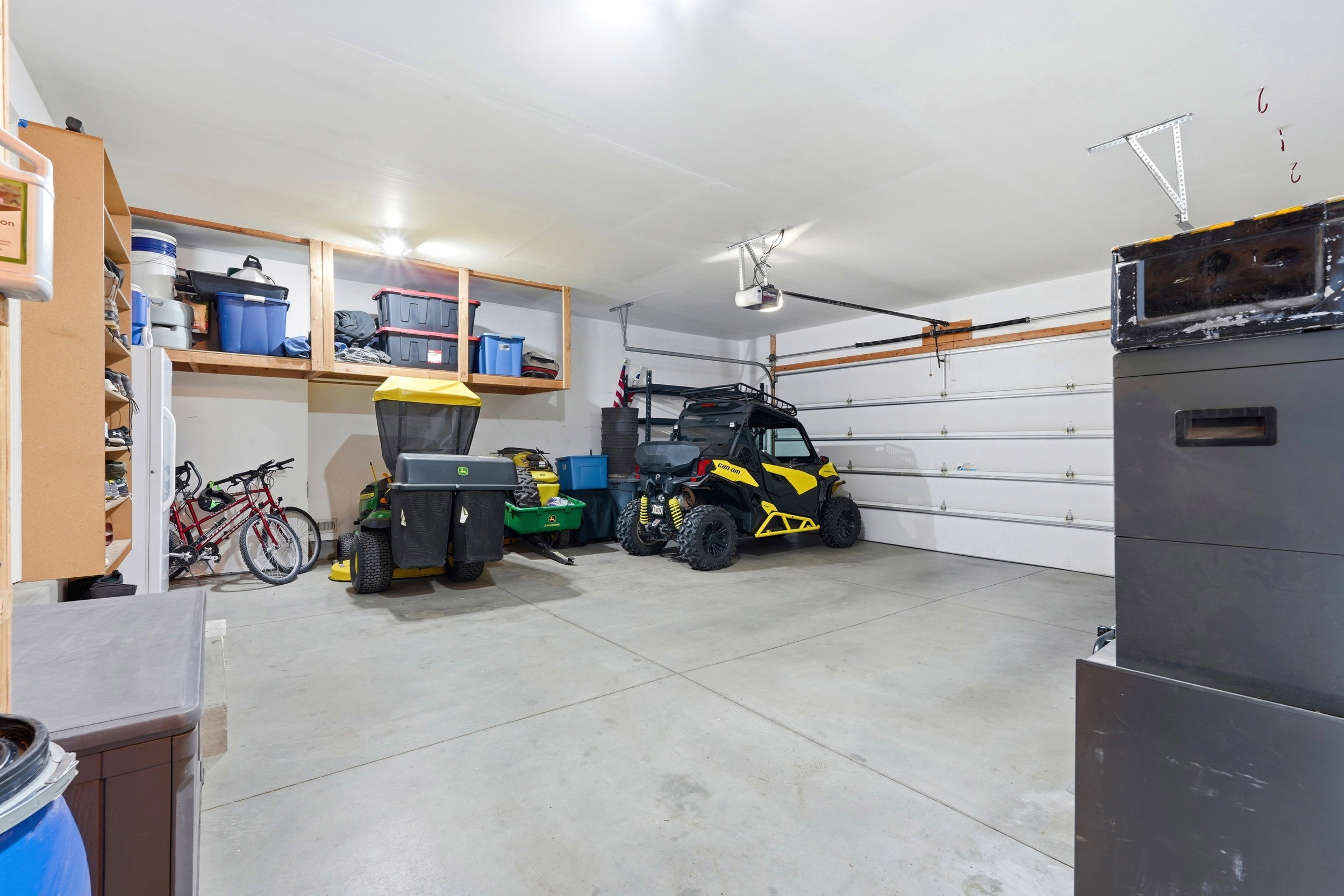 Spacious garage featuring a concrete floor, overhead lighting, and white paneled garage door