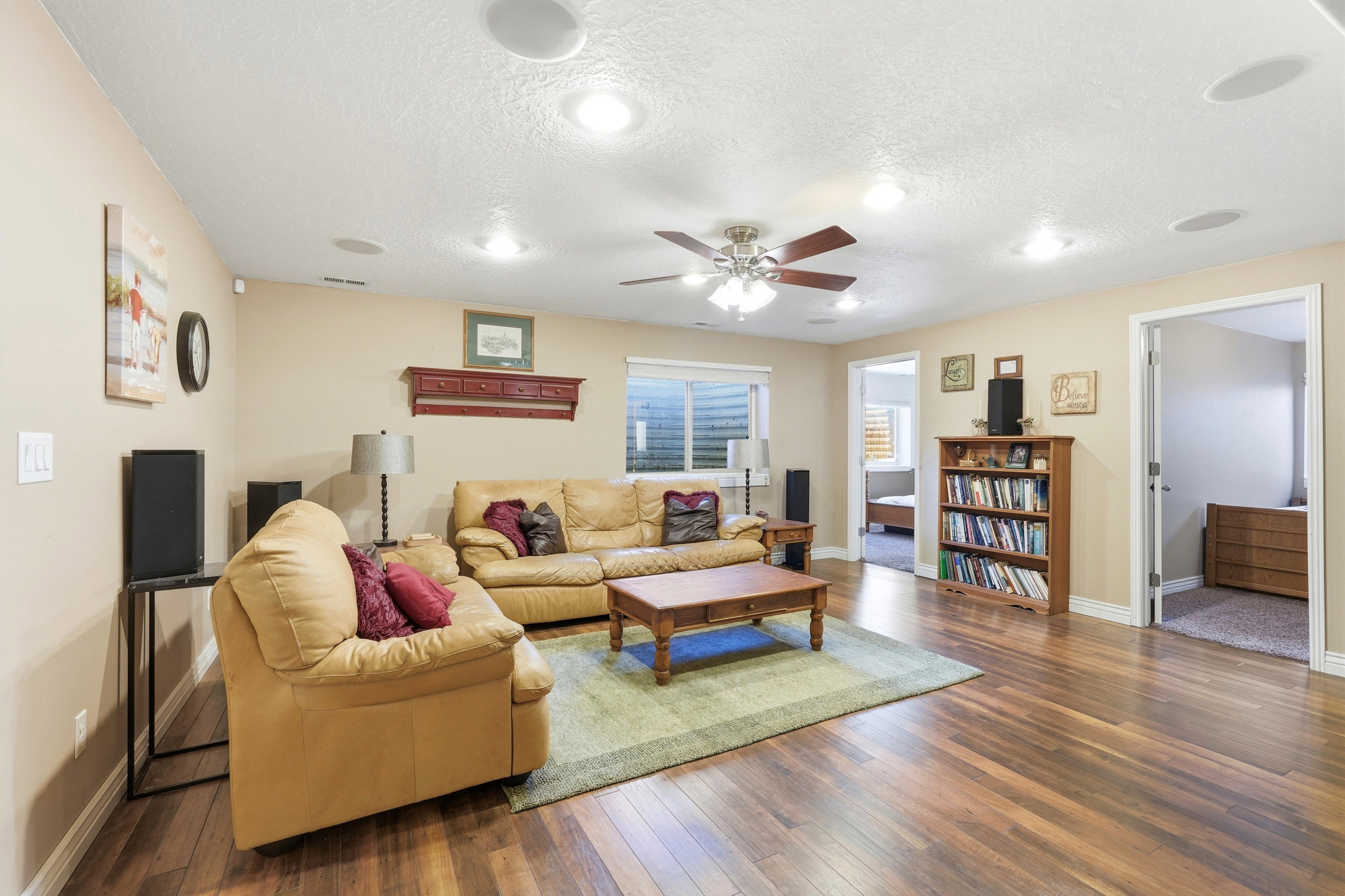 Spacious room featuring wood-finish flooring, recessed ceiling lights, a ceiling fan, and painted walls