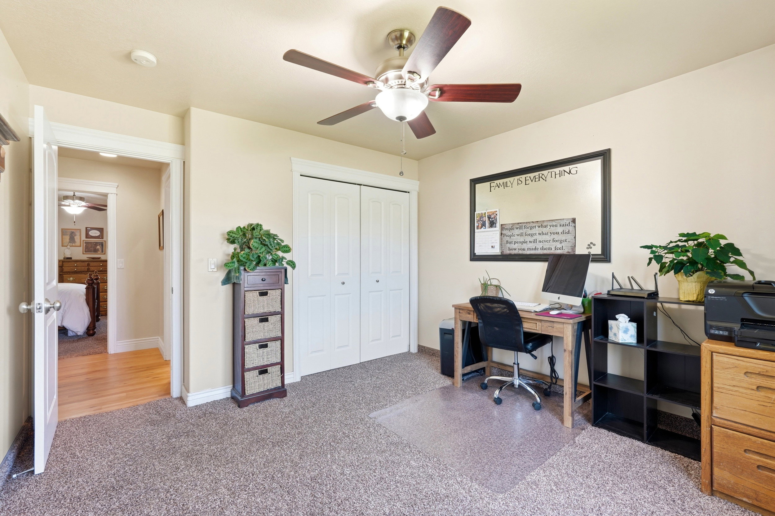 Room featuring neutral-toned walls, textured carpeting, and a ceiling fan with light fixture
