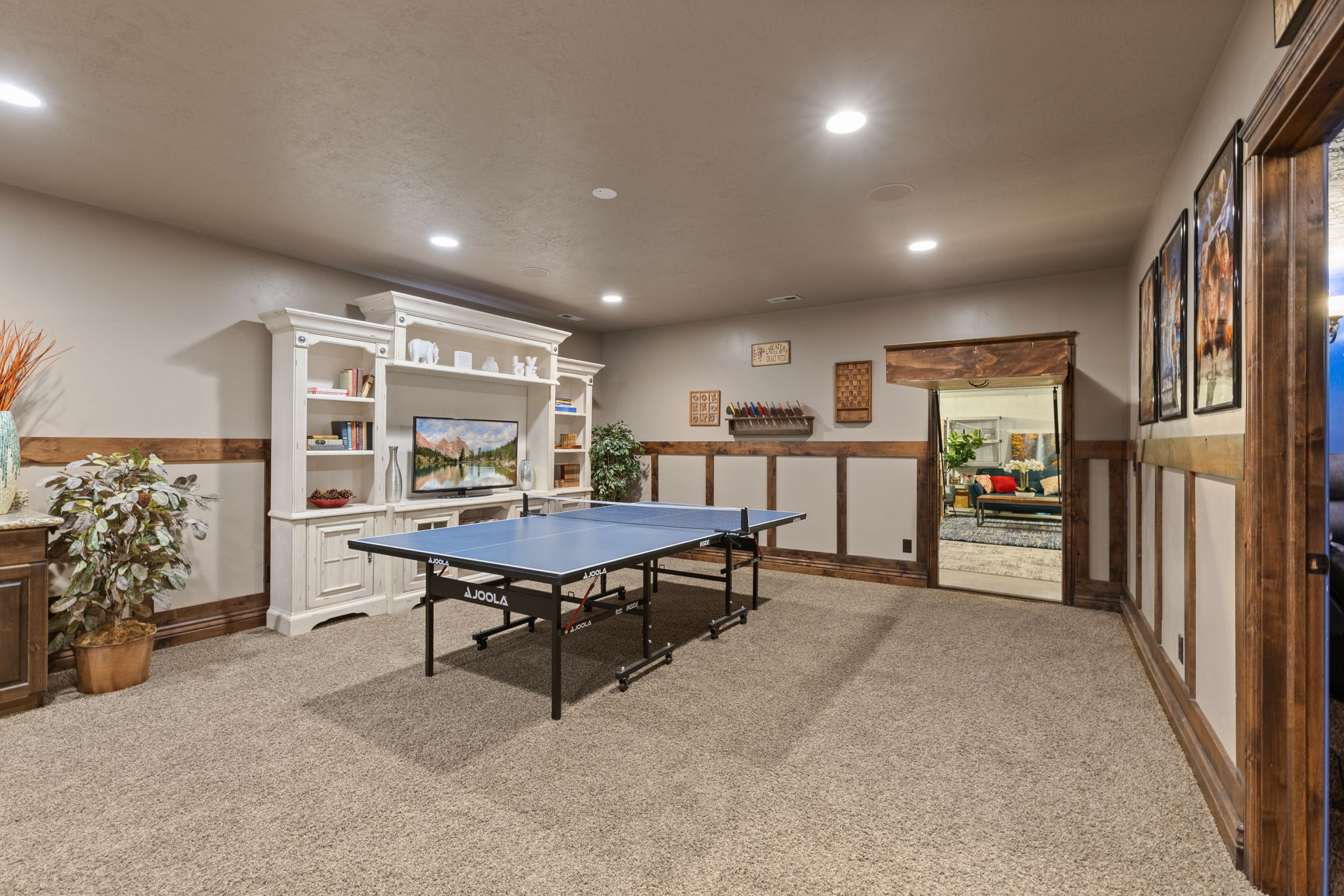 Spacious entertainment area featuring neutral-toned carpeting and recessed lighting
