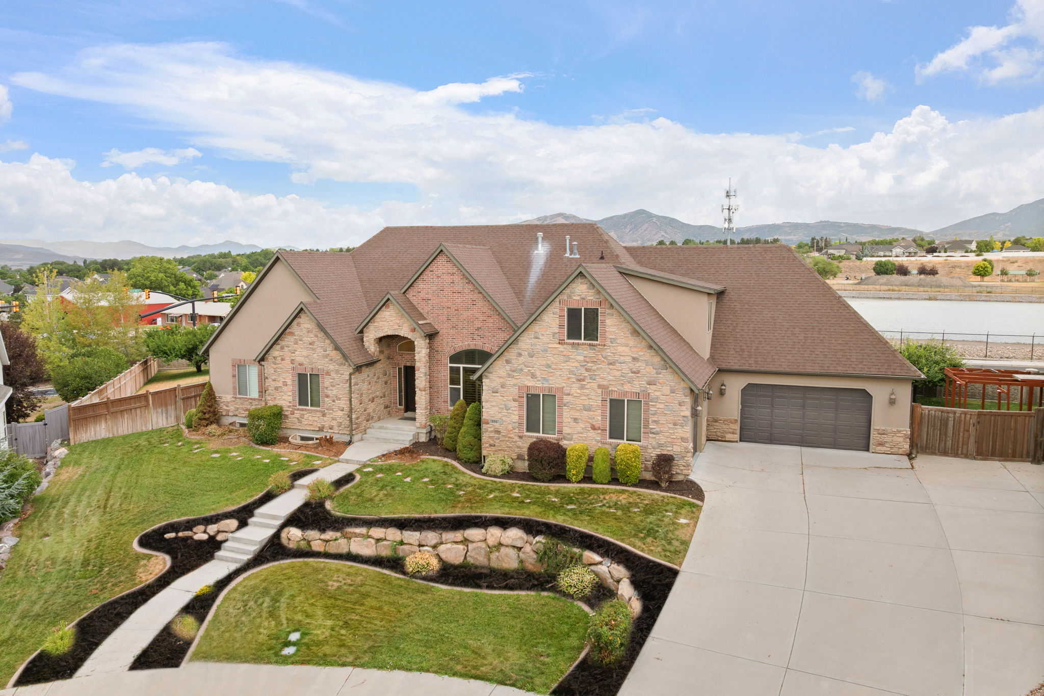 Stone and brick facade residence featuring a multi-gabled roofline and attached two-car garage